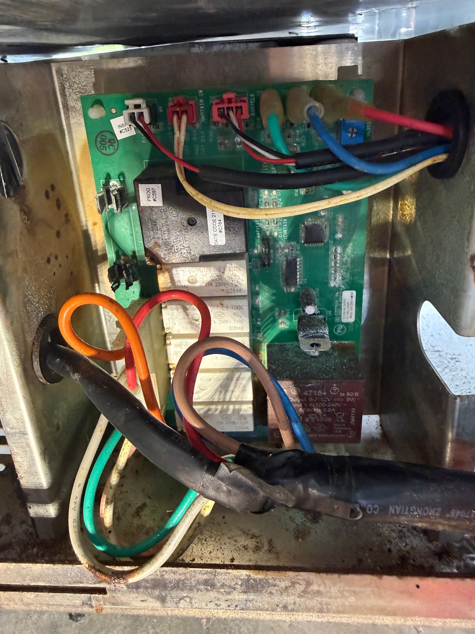Corroded wiring and water damage on the ice machine's original control board