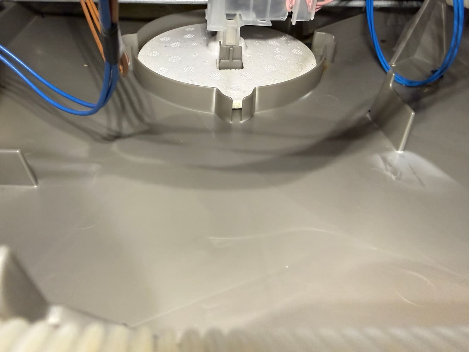 Residue buildup around the zeolite container mount inside the Bosch dishwasher