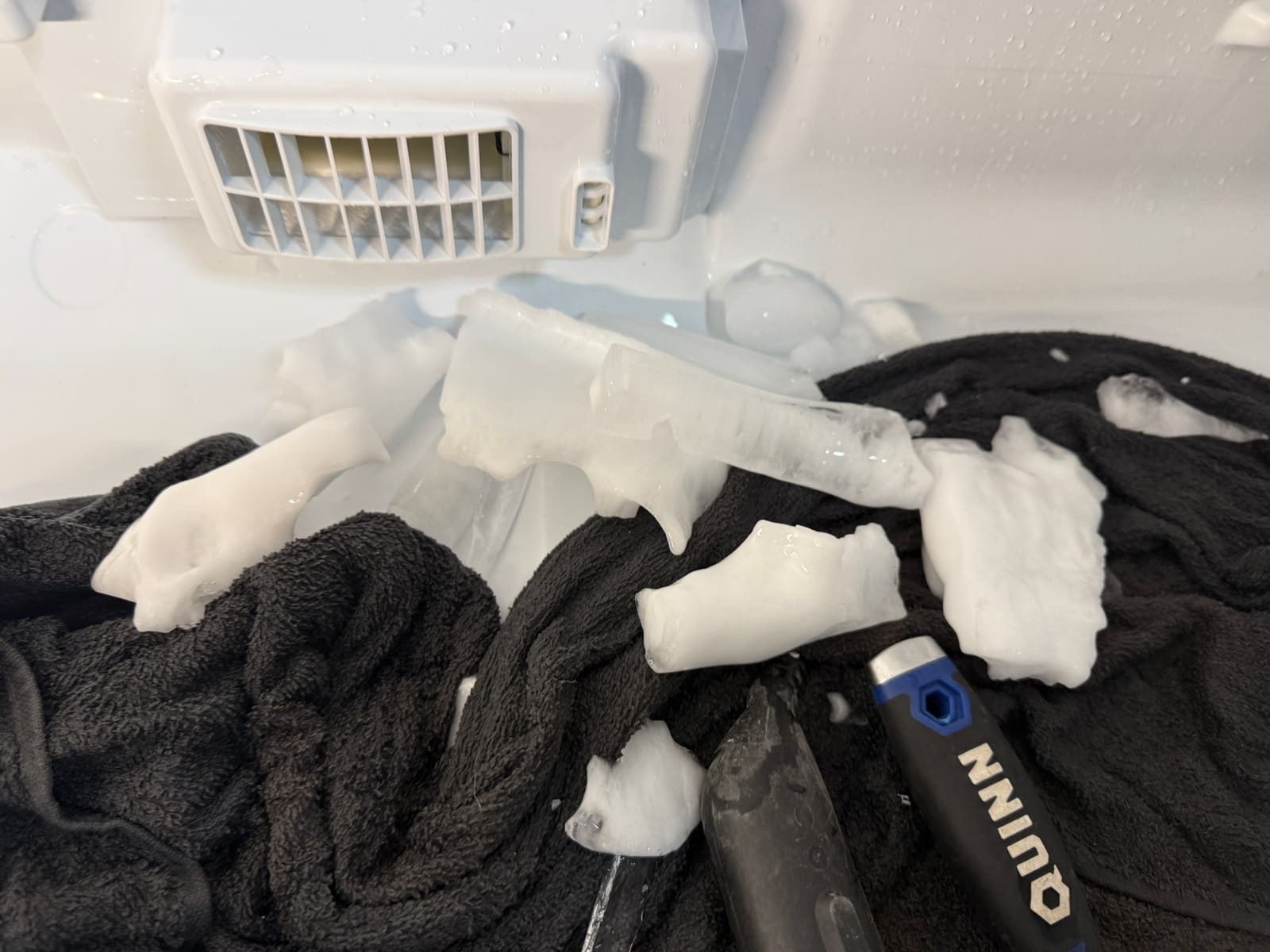 Large chunks of ice broken out of the Bosch refrigerator, lying on a towel