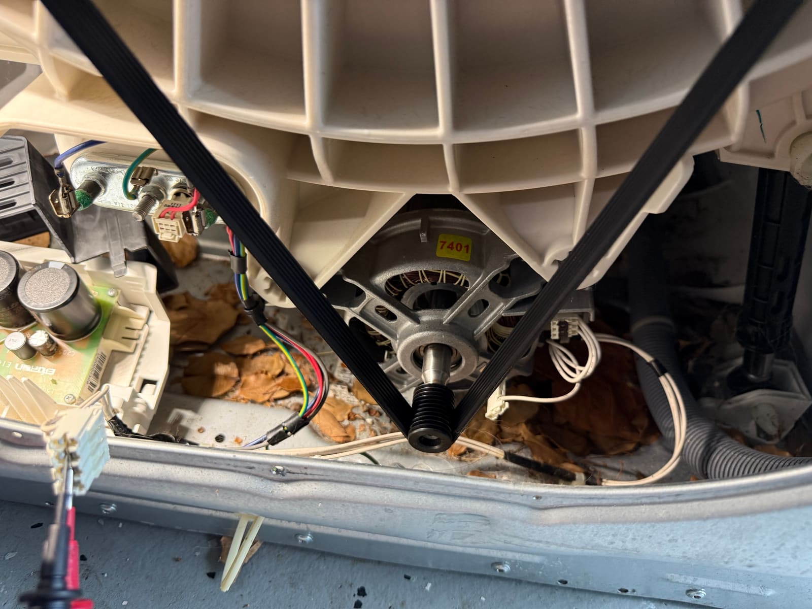 Drive motor and belt under the tub of the Electrolux washer, with the inverter board on the left