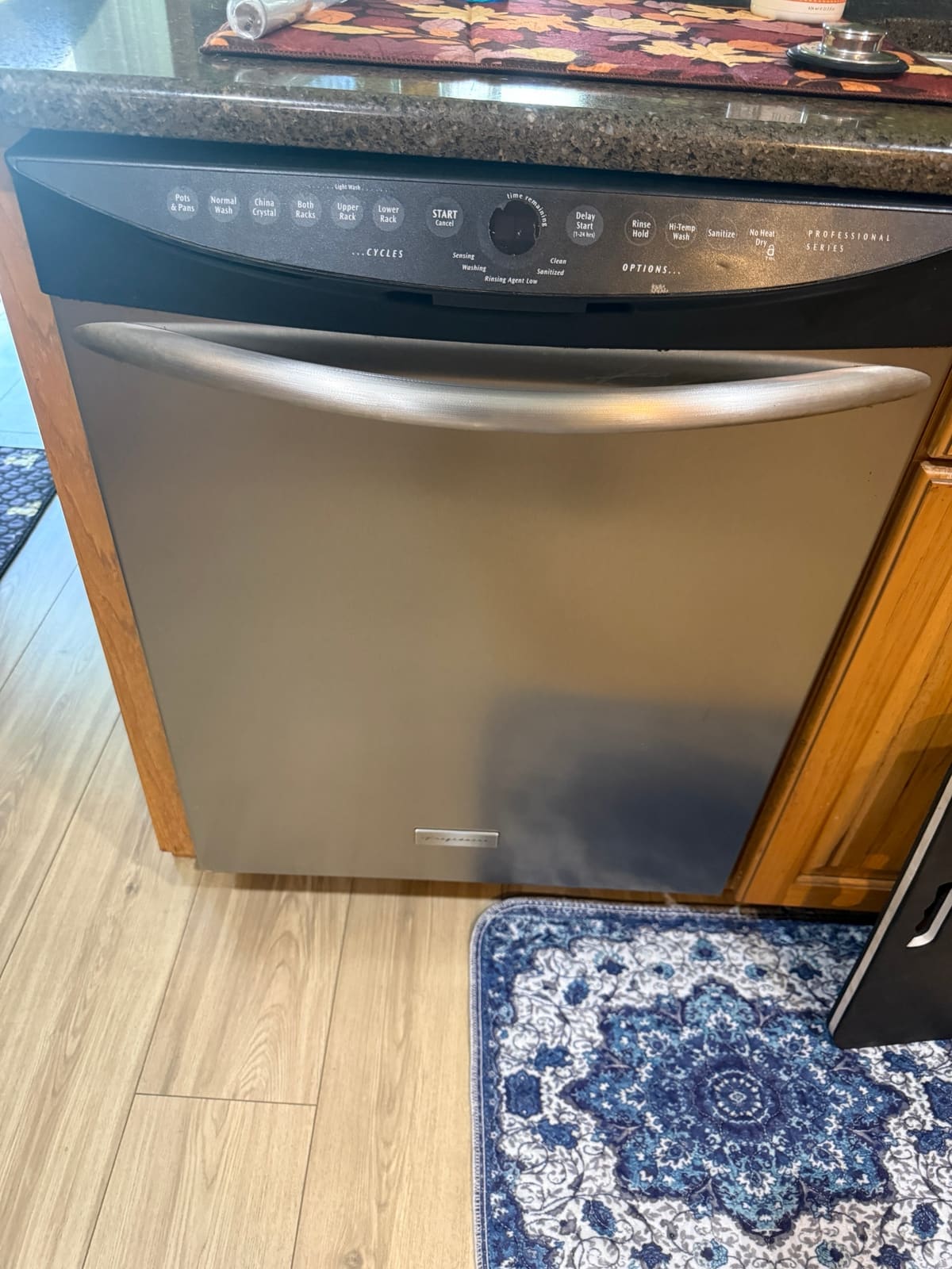 Stainless Frigidaire Professional Series dishwasher built into wood cabinets in a Wexford Leas, Palm Harbor kitchen