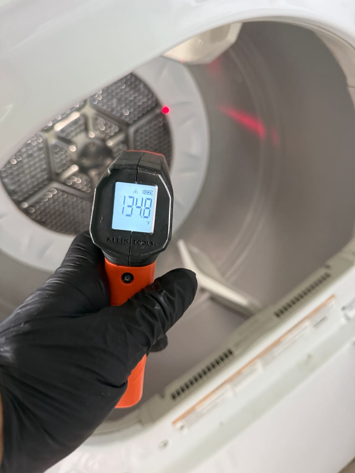 Infrared thermometer reading about 135 degrees Fahrenheit inside the GE dryer drum after the repair