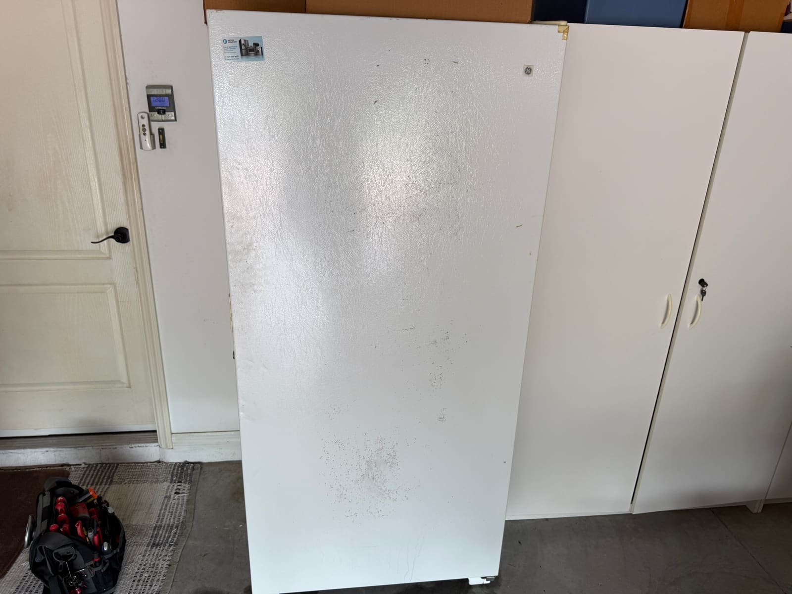 GE upright freezer in a garage in Trinity