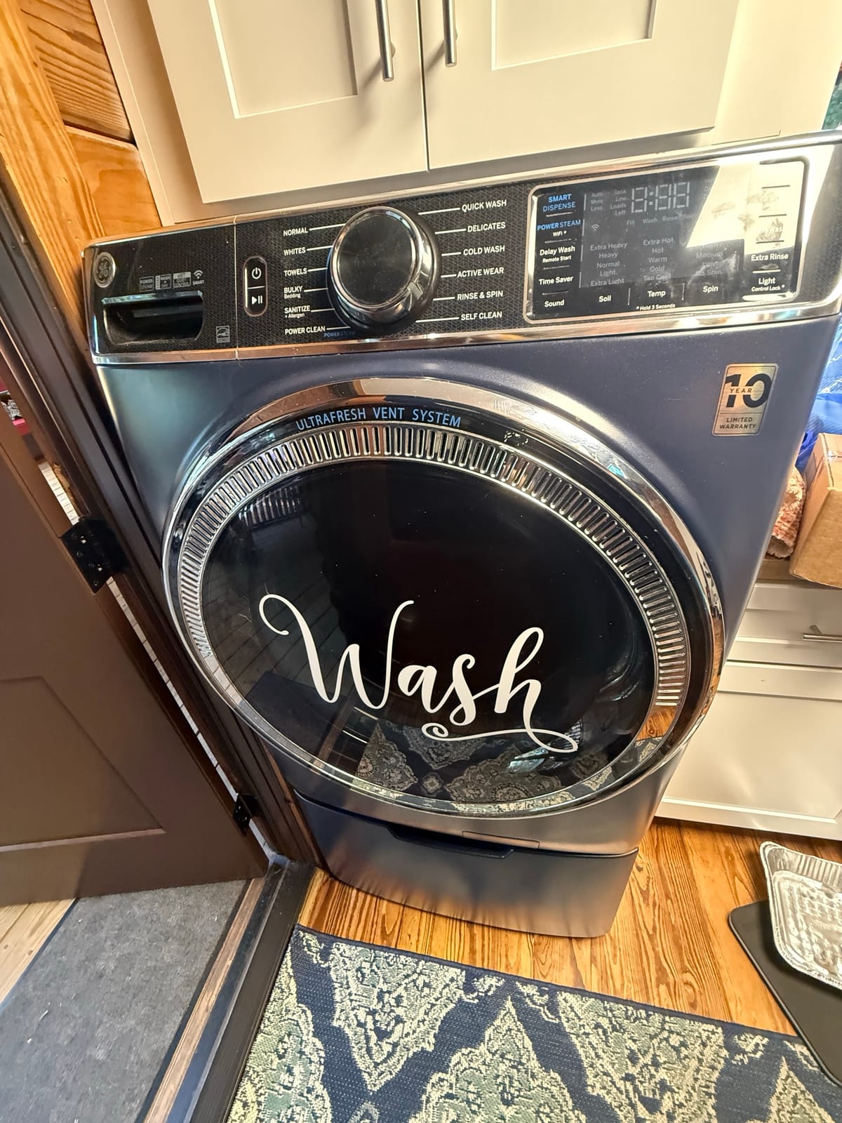 Blue GE front-load washer on a pedestal drawer in a Palm Harbor laundry nook