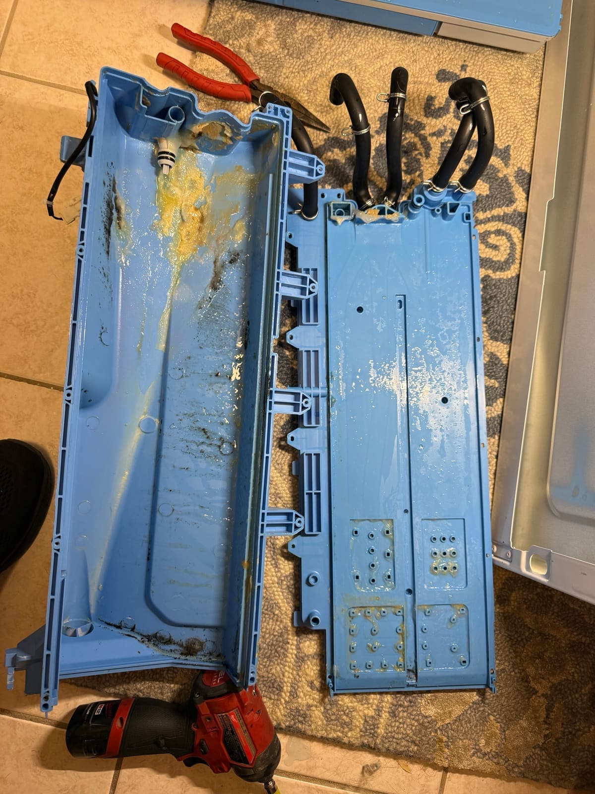 GE washer dispenser housing opened up, with thick yellow residue and dark gunk caked inside