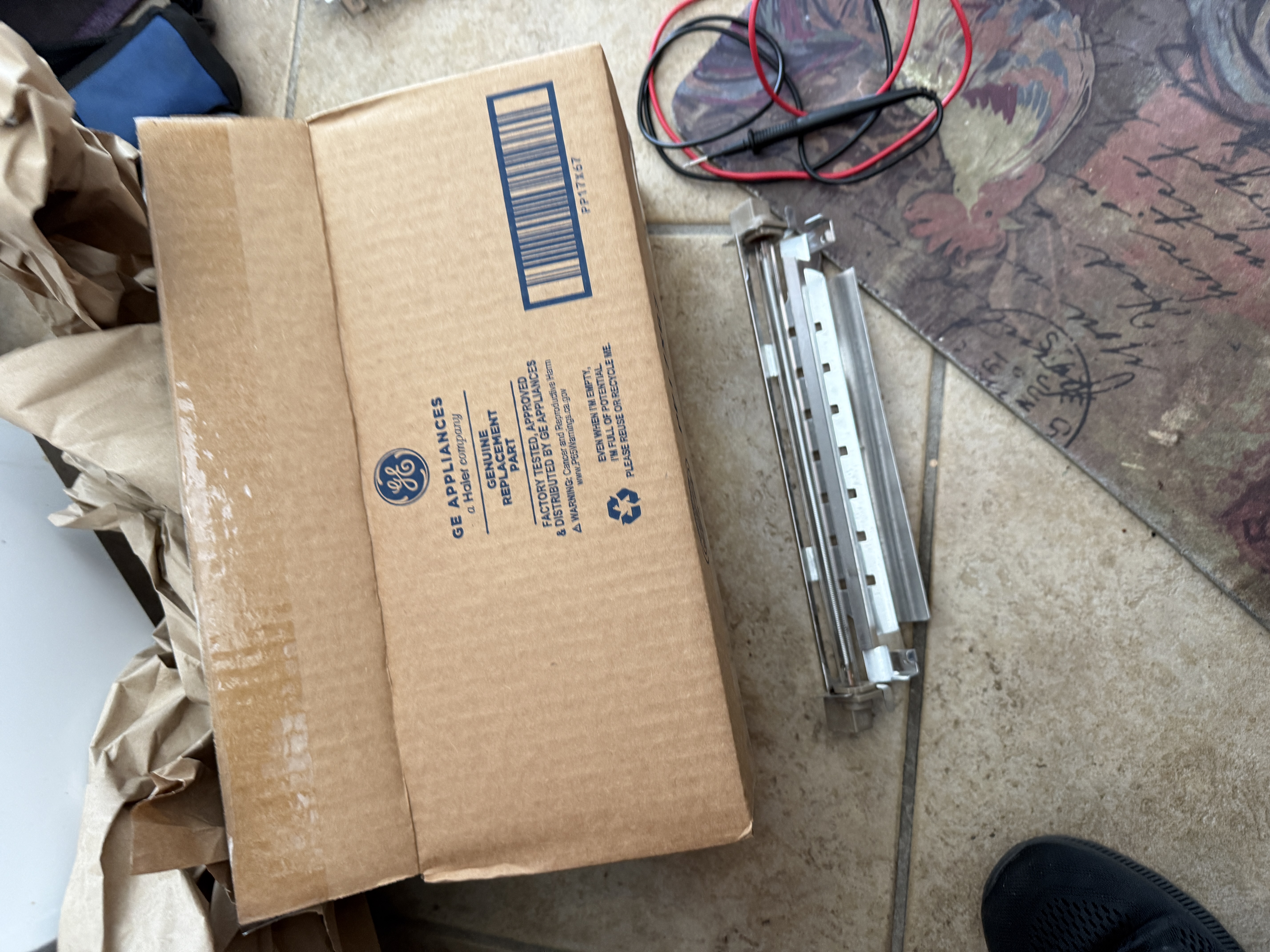 New GE genuine replacement defrost heater next to the old damaged glass heater