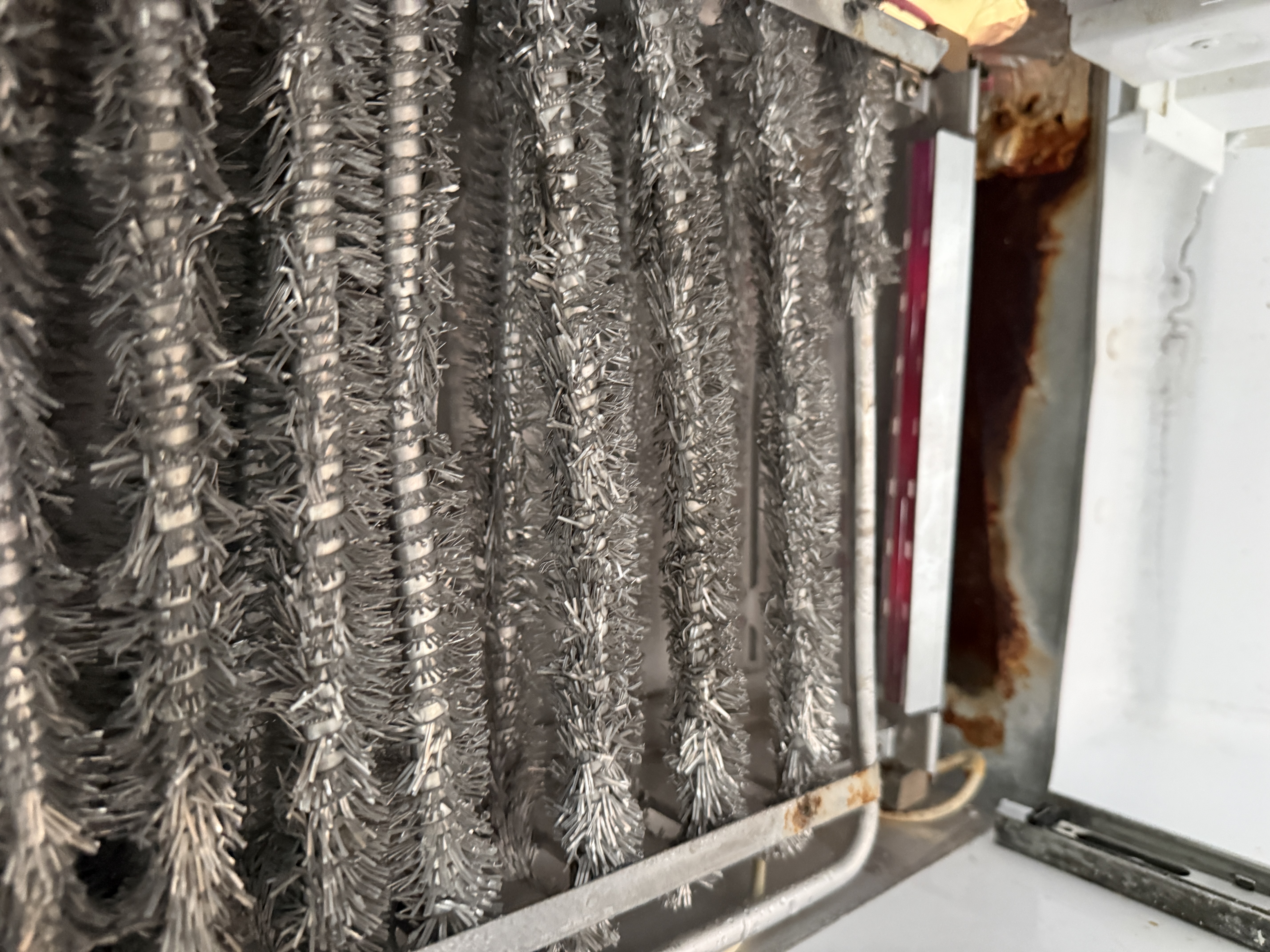 Evaporator coil assembly in the GE refrigerator, near the defrost heater