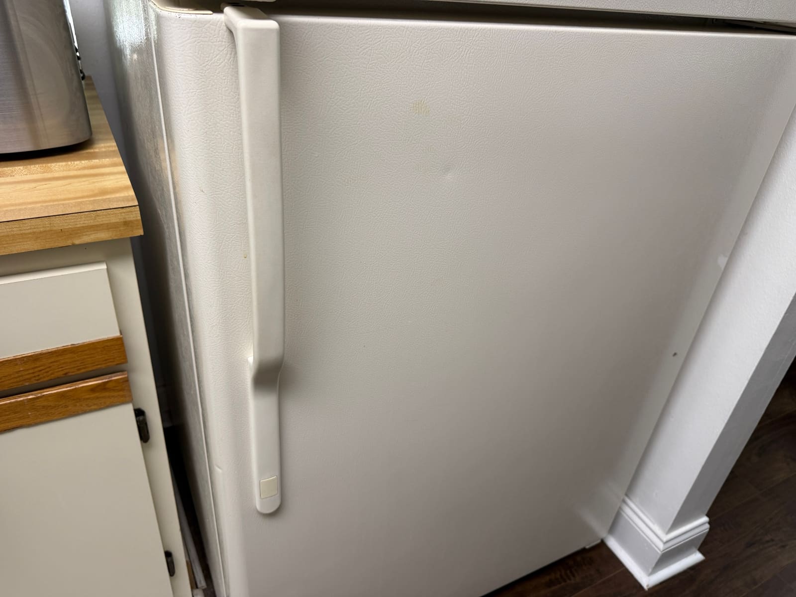 Older bisque GE top-freezer refrigerator in a kitchen in Oldsmar