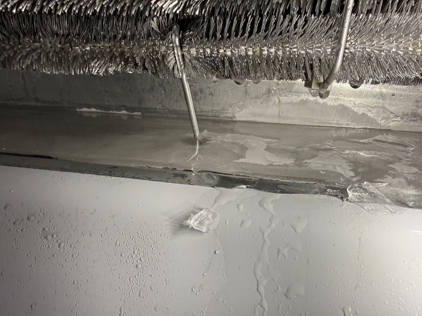 Ice buildup around the frozen defrost drain area inside the freezer compartment