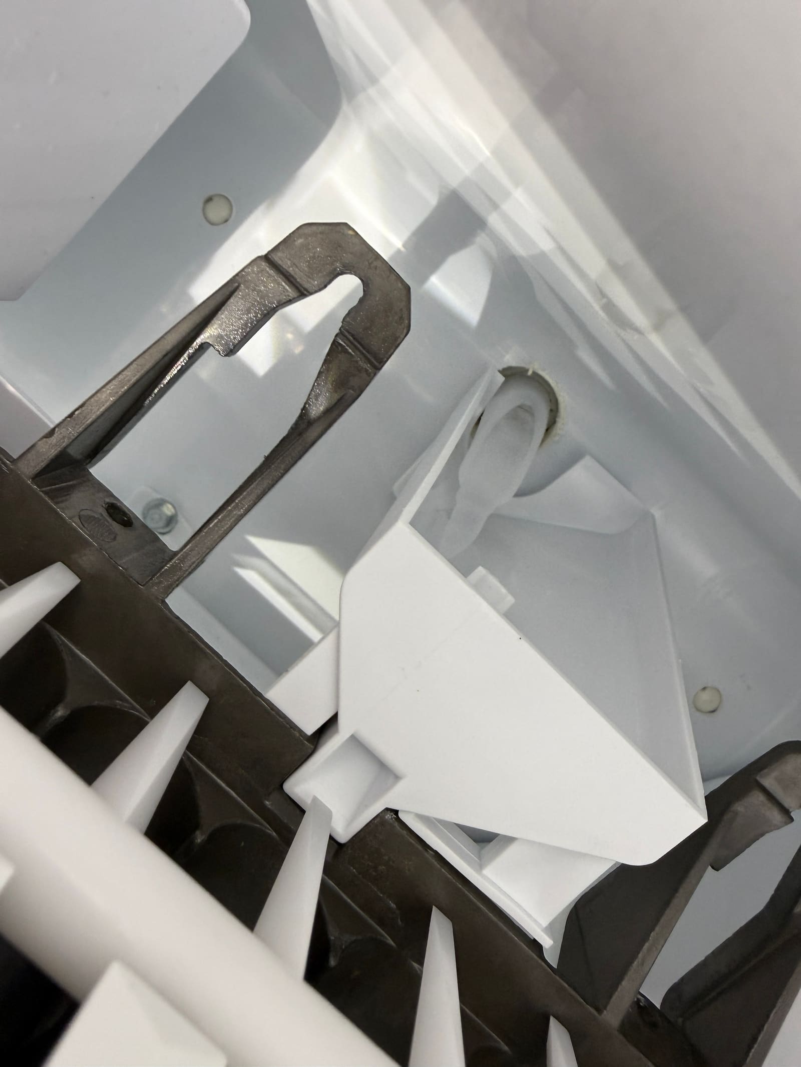 Inside the GE ice maker, with an empty mold and no water in the cavities