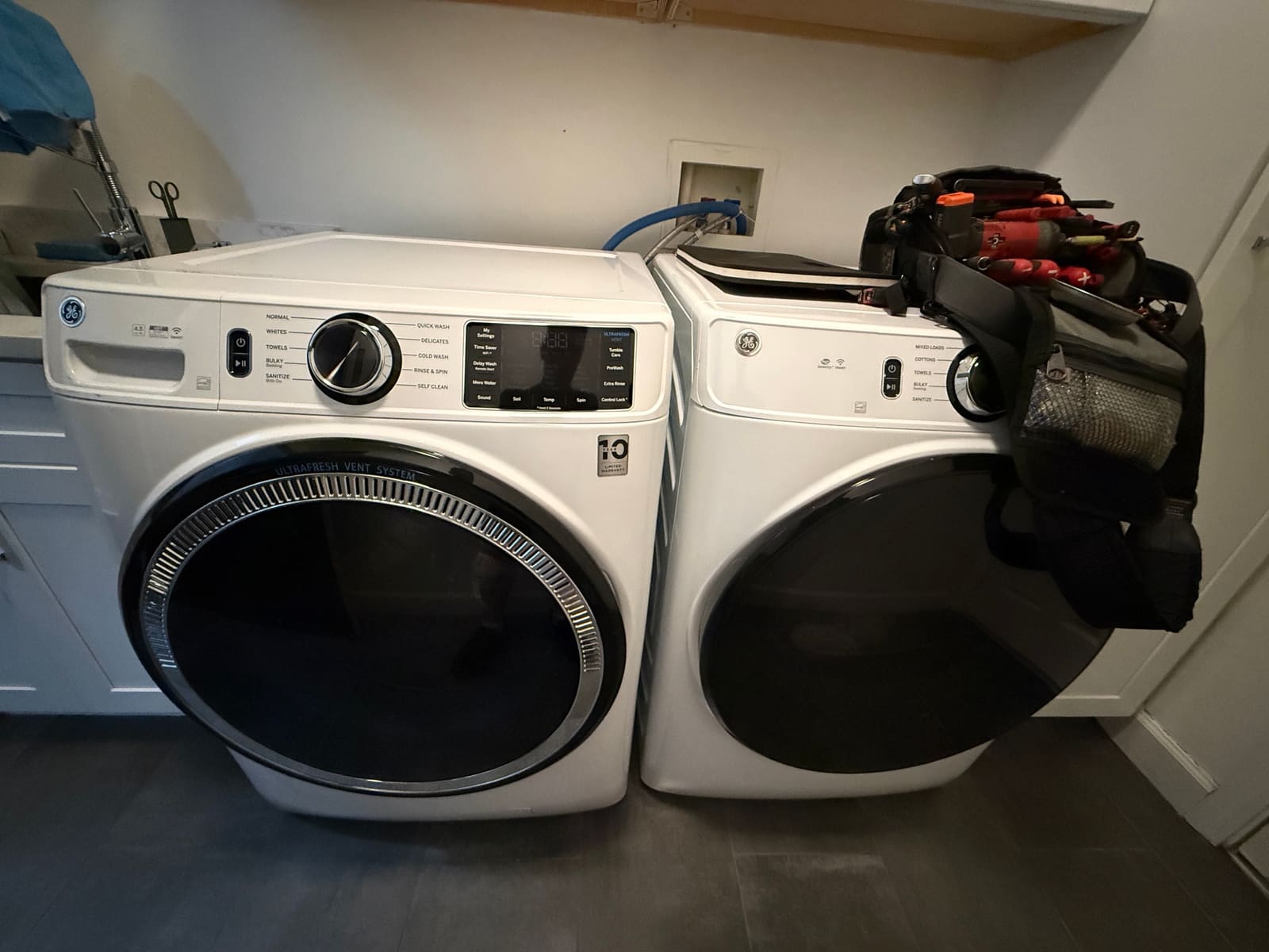 White GE front-load washer and dryer pair in a laundry room in Trinity
