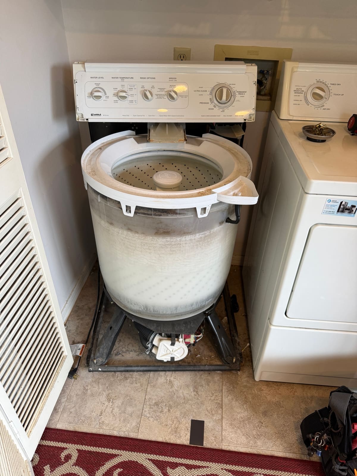 Kenmore top-load washer with the cabinet removed, showing the outer tub, the drain pump and the motor underneath