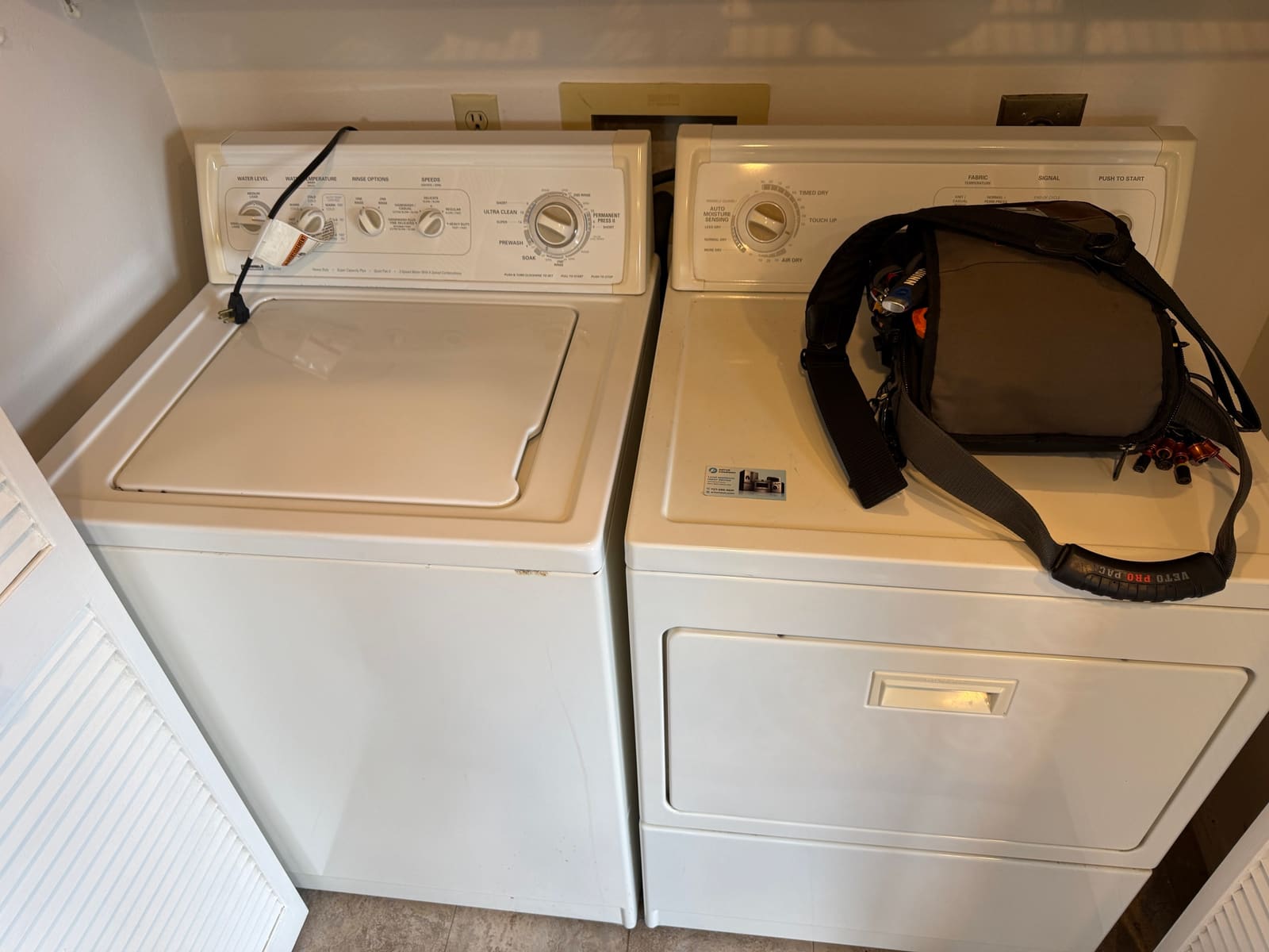 Kenmore 90 Series top-load washer next to a matching Kenmore dryer in a laundry closet in Clearwater