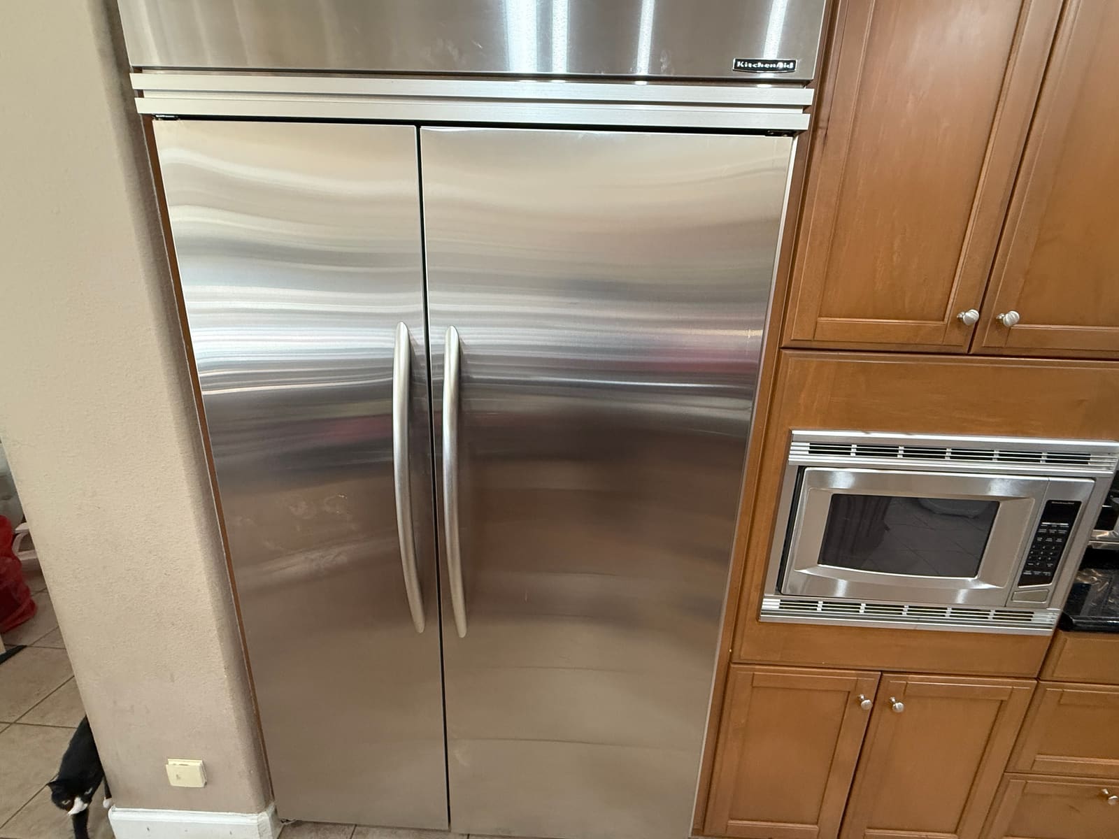 KitchenAid built-in side-by-side refrigerator with stainless doors next to wood cabinetry in a kitchen in Palm Harbor