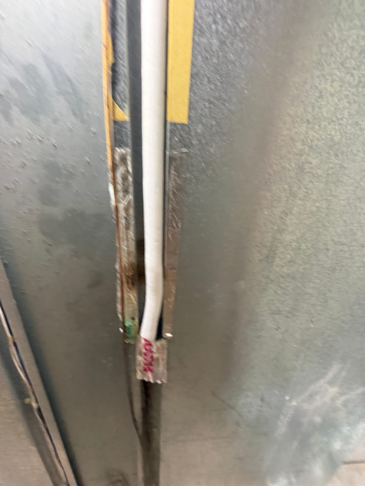 The repaired line wrapped in white insulation and taped in place