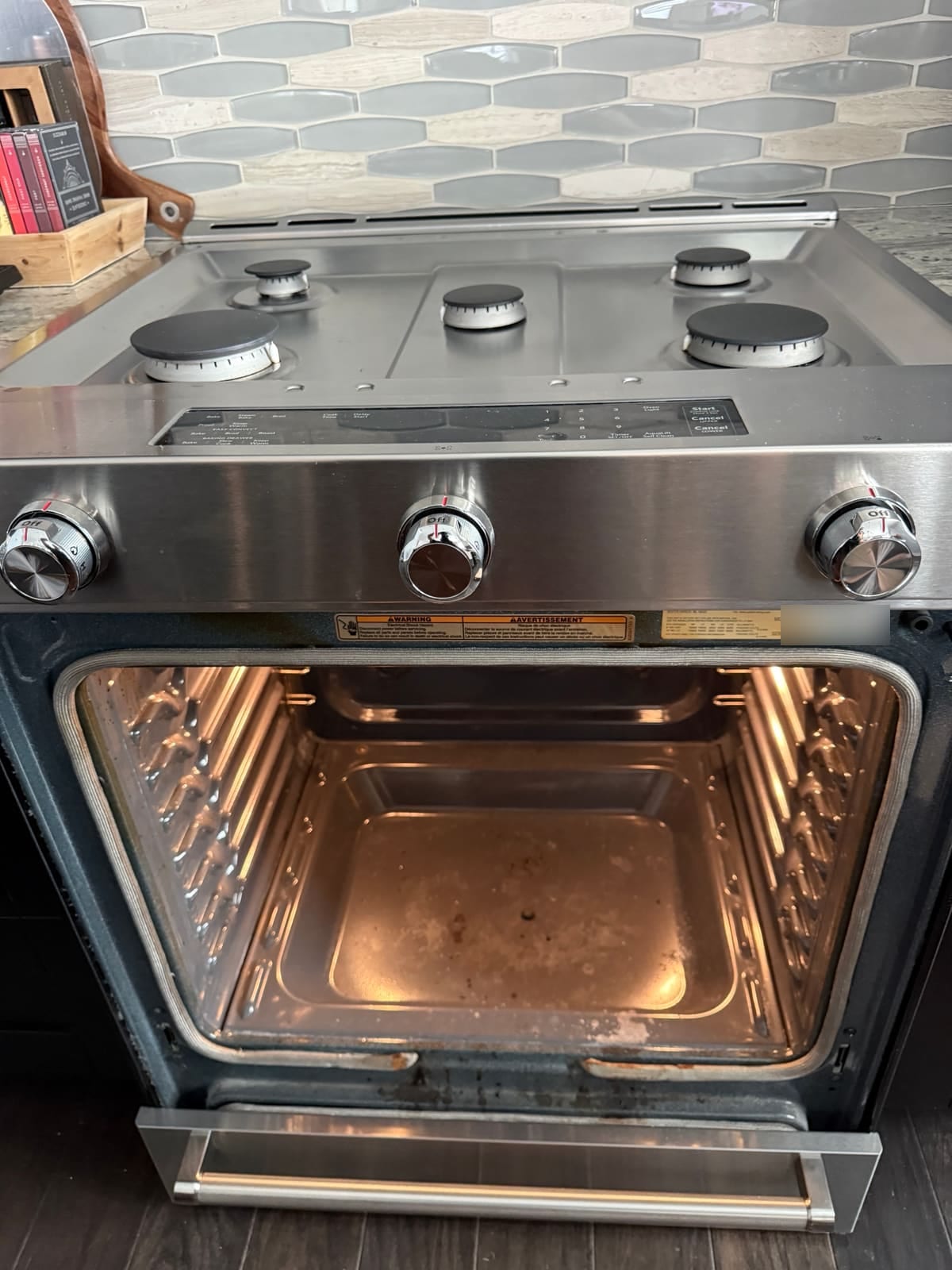 KitchenAid oven with the door removed and the racks taken out, ready to lift out the oven floor panel