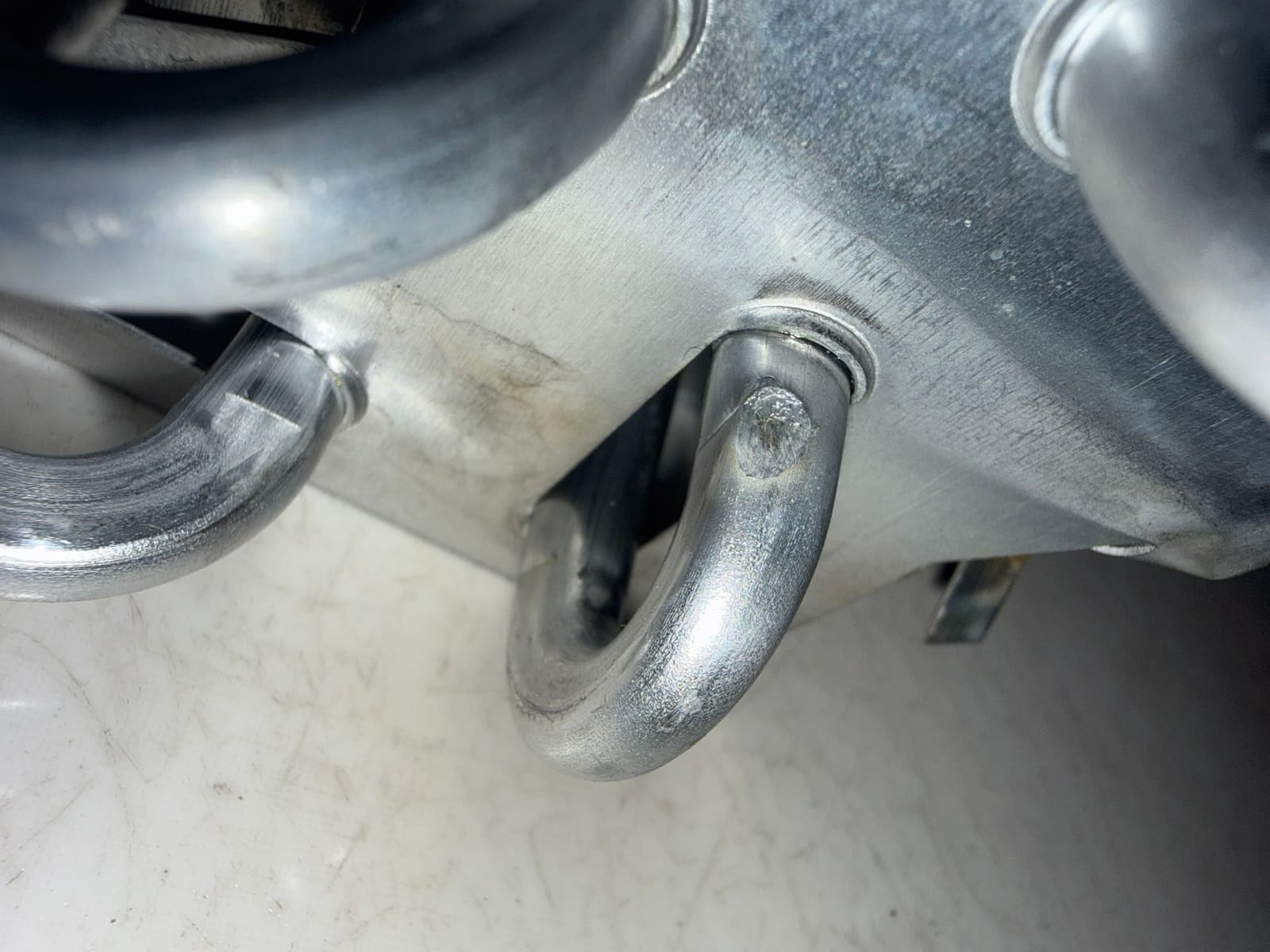 Permanent brazed service valve access port installed on the refrigerator's exterior panel