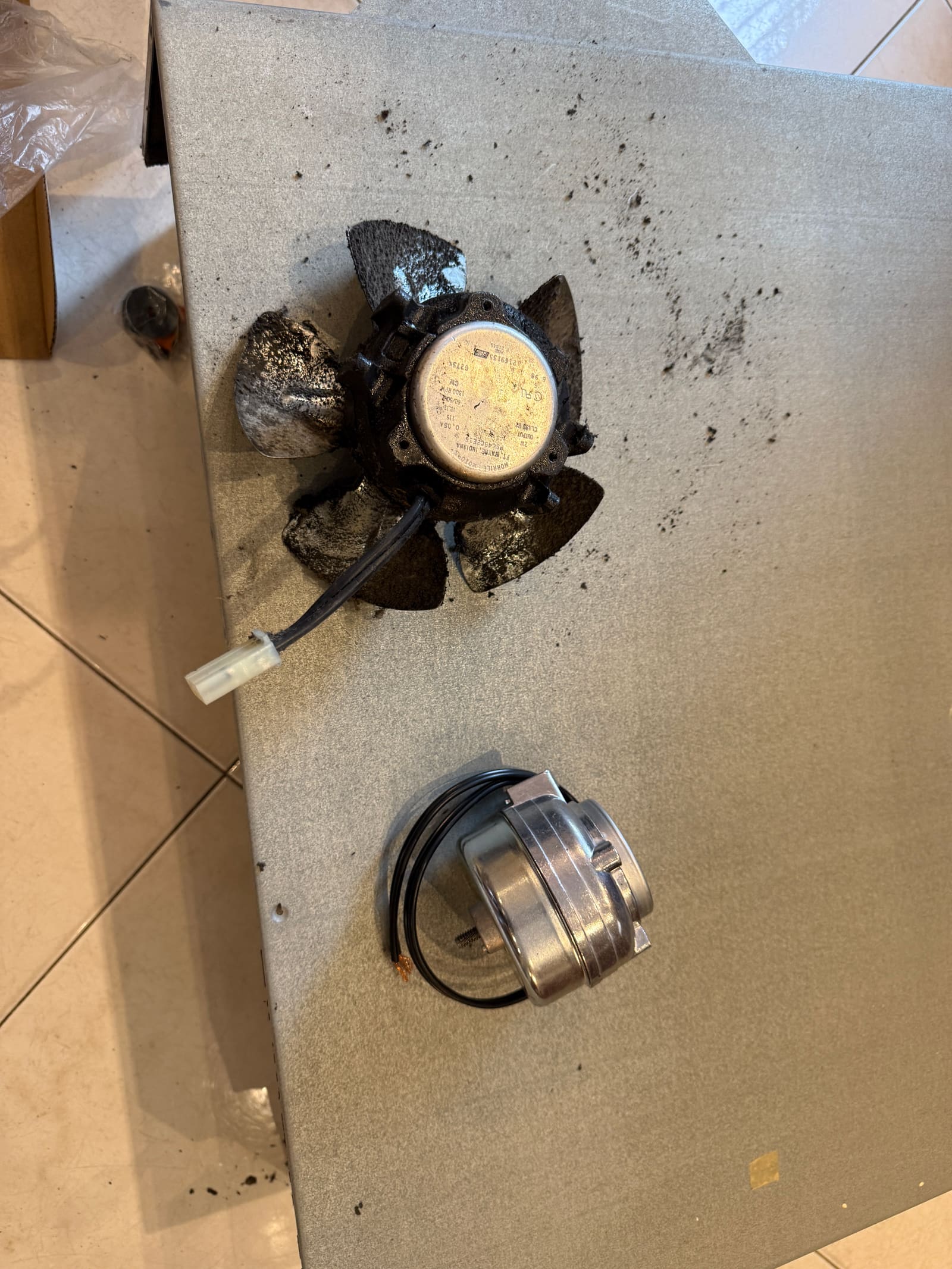 Old condenser fan motor next to the new replacement motor