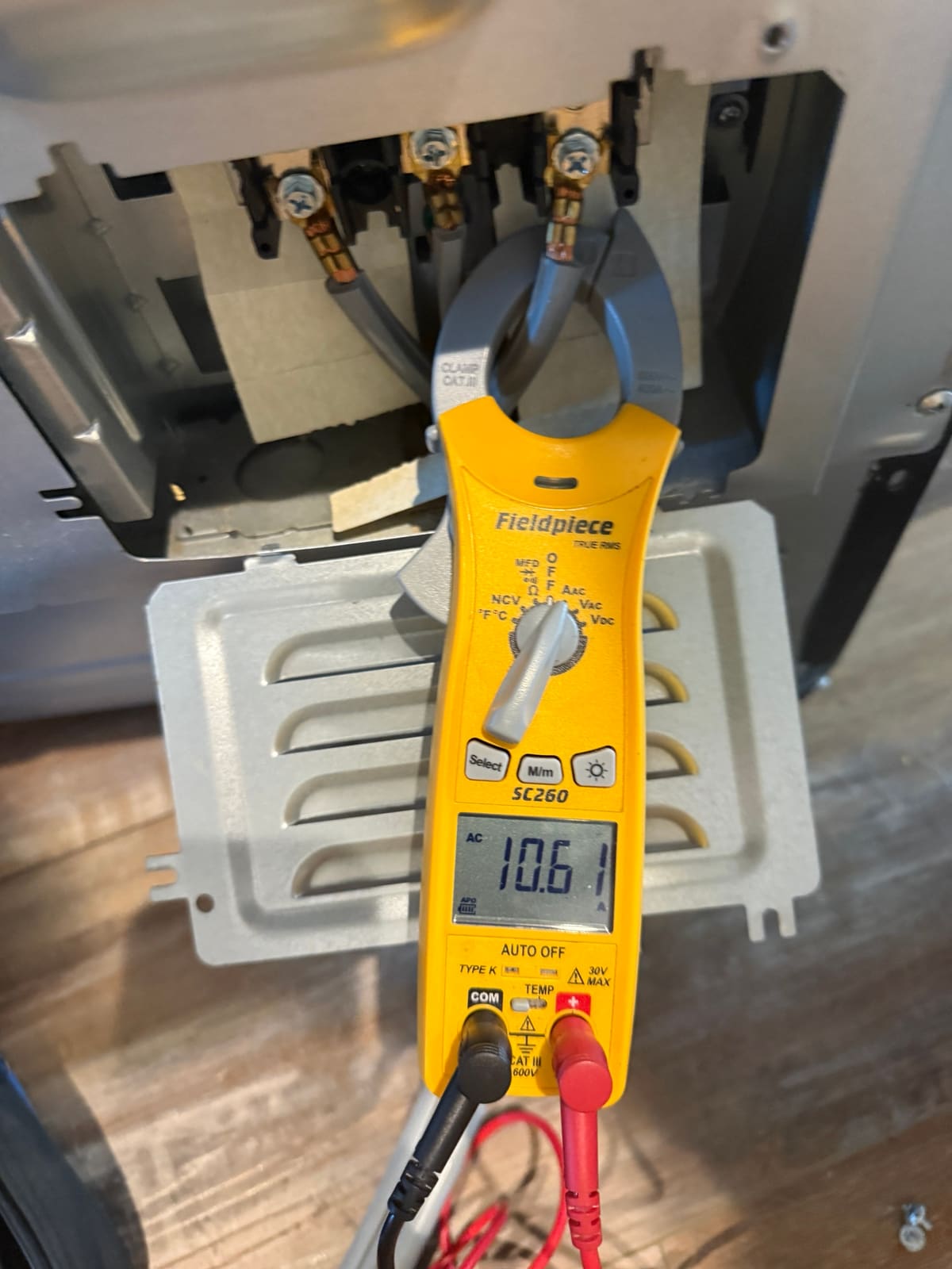 Clamp meter reading current on the LG range power supply wires at the terminal block