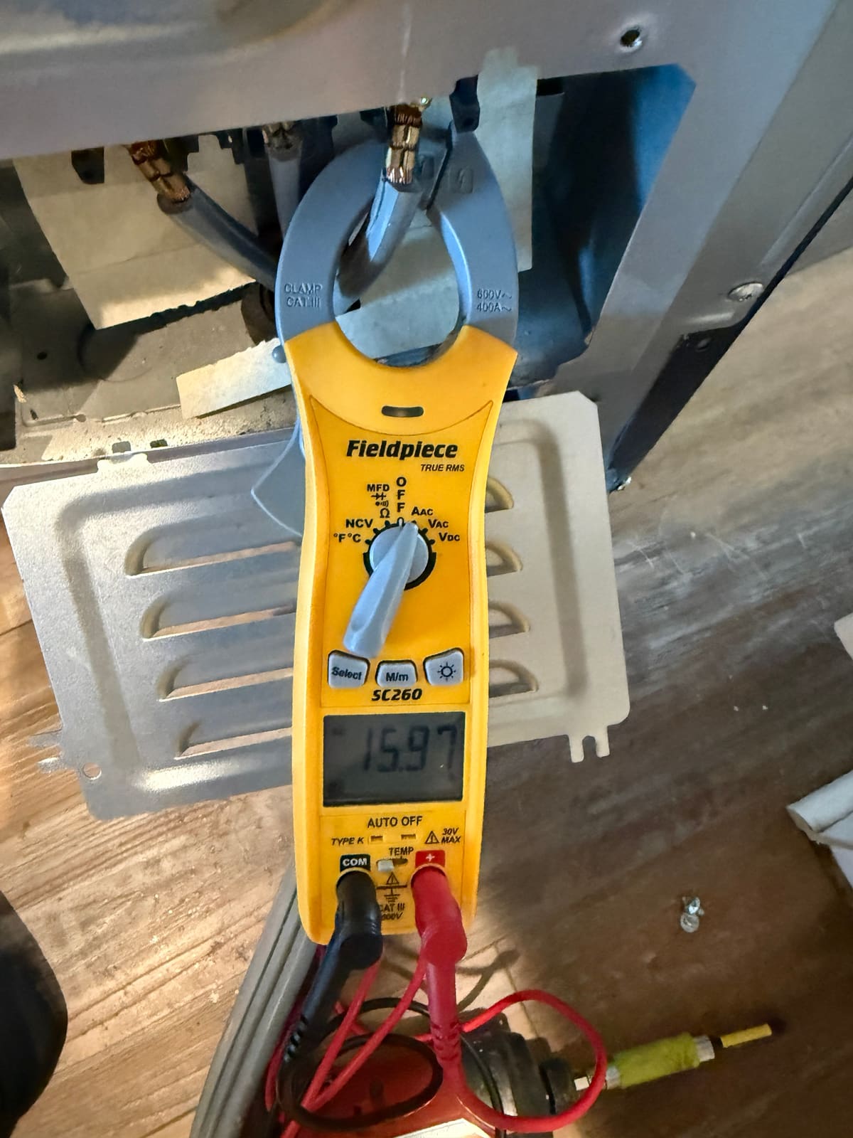 Clamp meter on a power wire at the LG range terminal block showing current draw while an oven heats