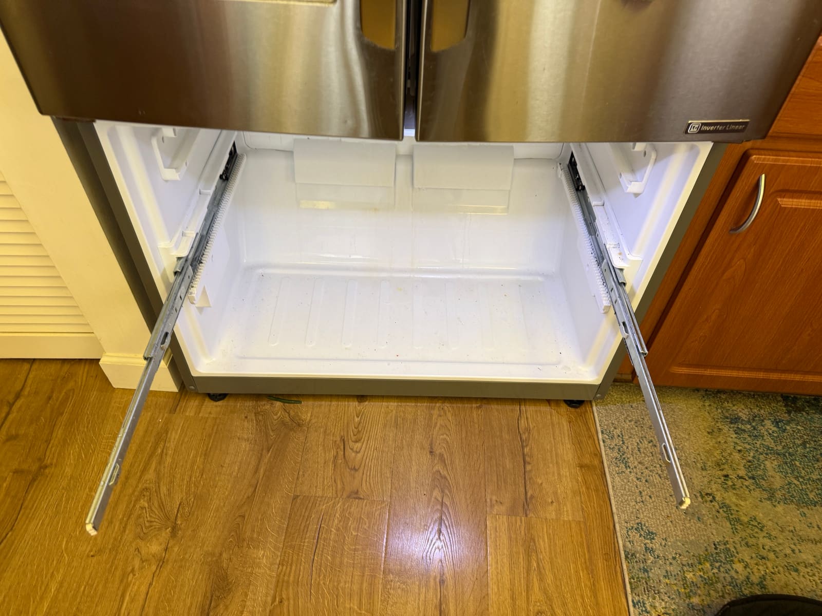 LG French door refrigerator with the freezer drawer removed and both drawer slides pulled out, in the Highland Lakes neighborhood of Palm Harbor