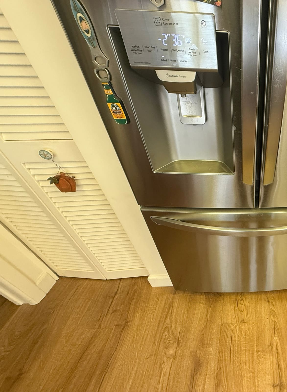 LG French door refrigerator with an ice and water dispenser and the bottom freezer drawer closed