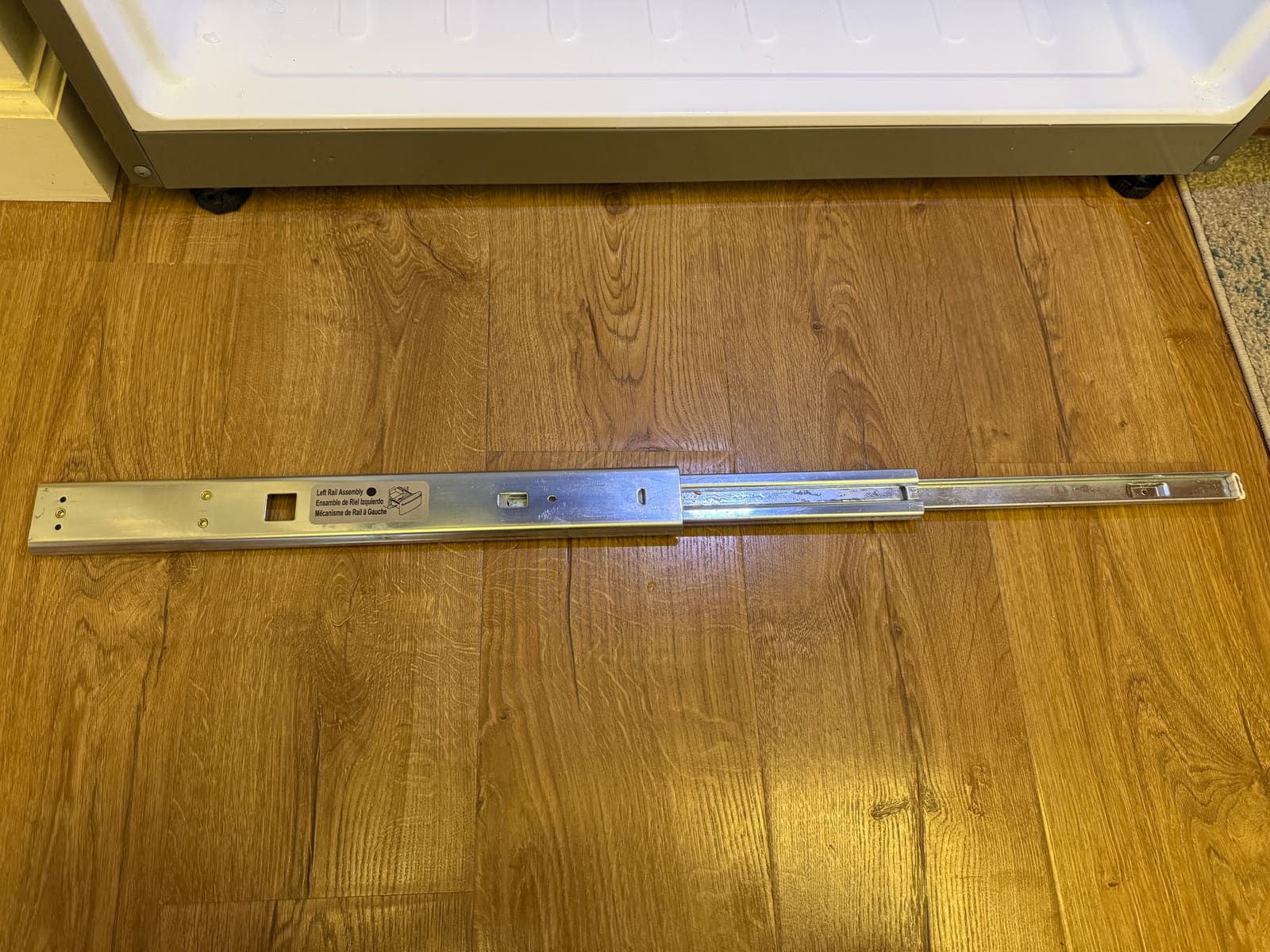 LG left rail assembly for the freezer drawer, removed and laid out on the floor