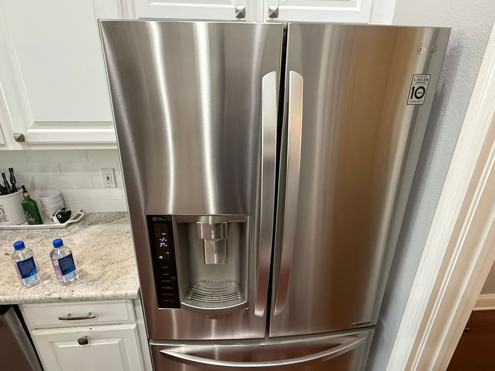 Stainless steel LG French door refrigerator with a door dispenser in a kitchen in Westchase