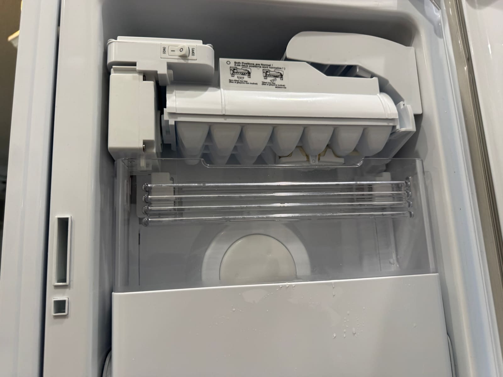 New LG ice maker assembly installed in the freezer door with a clean, empty ice bin