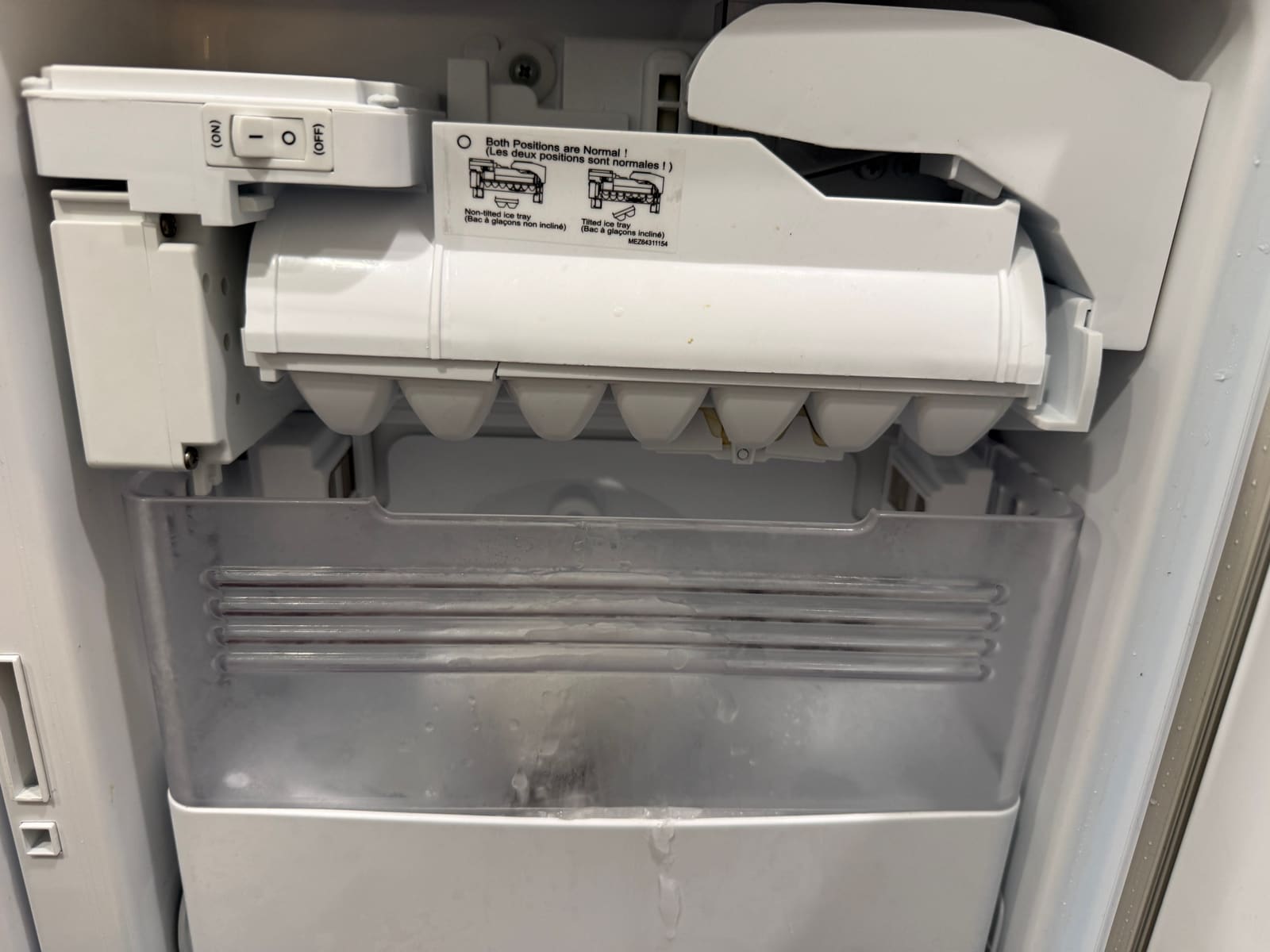 Original LG ice maker in the freezer door with ice built up in the bin below it