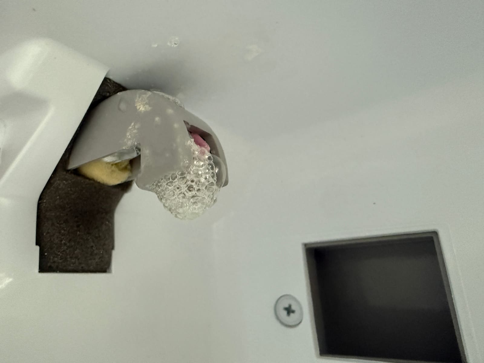 Damaged fill cup on the ice maker assembly where water pours in to freeze