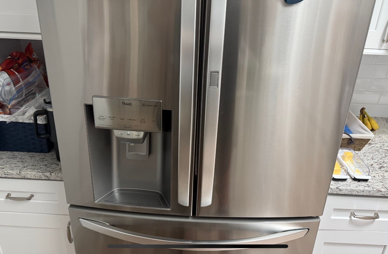 Stainless steel LG French door refrigerator with a ThinQ ice and water dispenser in a kitchen in Palm Harbor