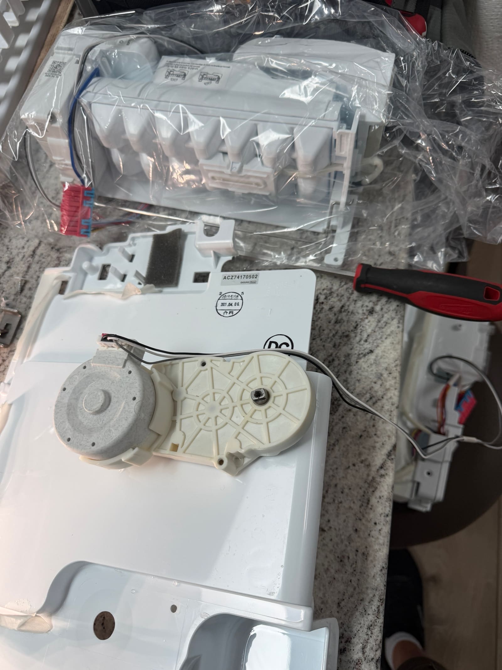Old ice maker assembly removed from the freezer for a closer look at the damage