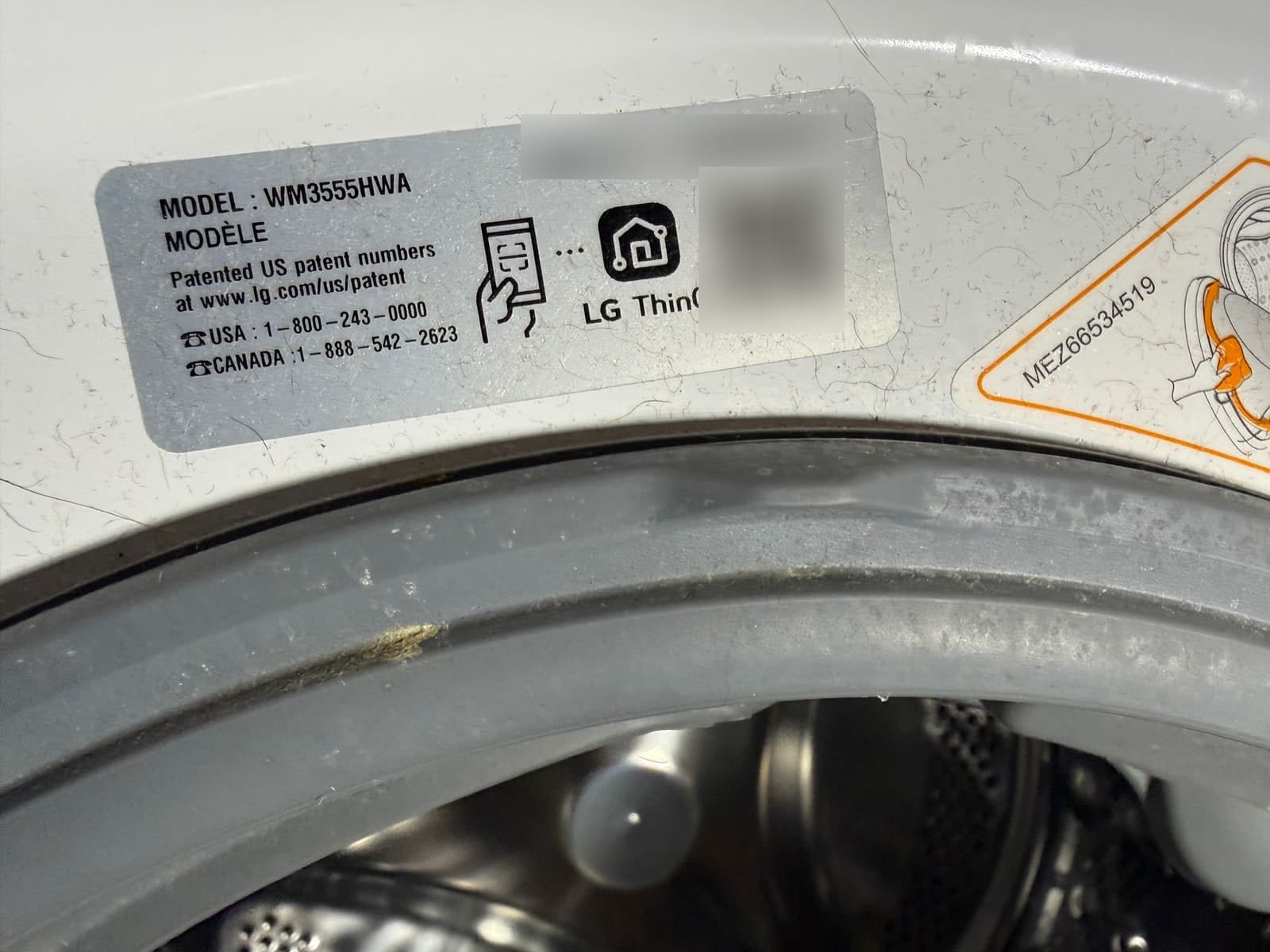 LG washer data plate, model WM3555HWA, with the serial number and QR code blurred