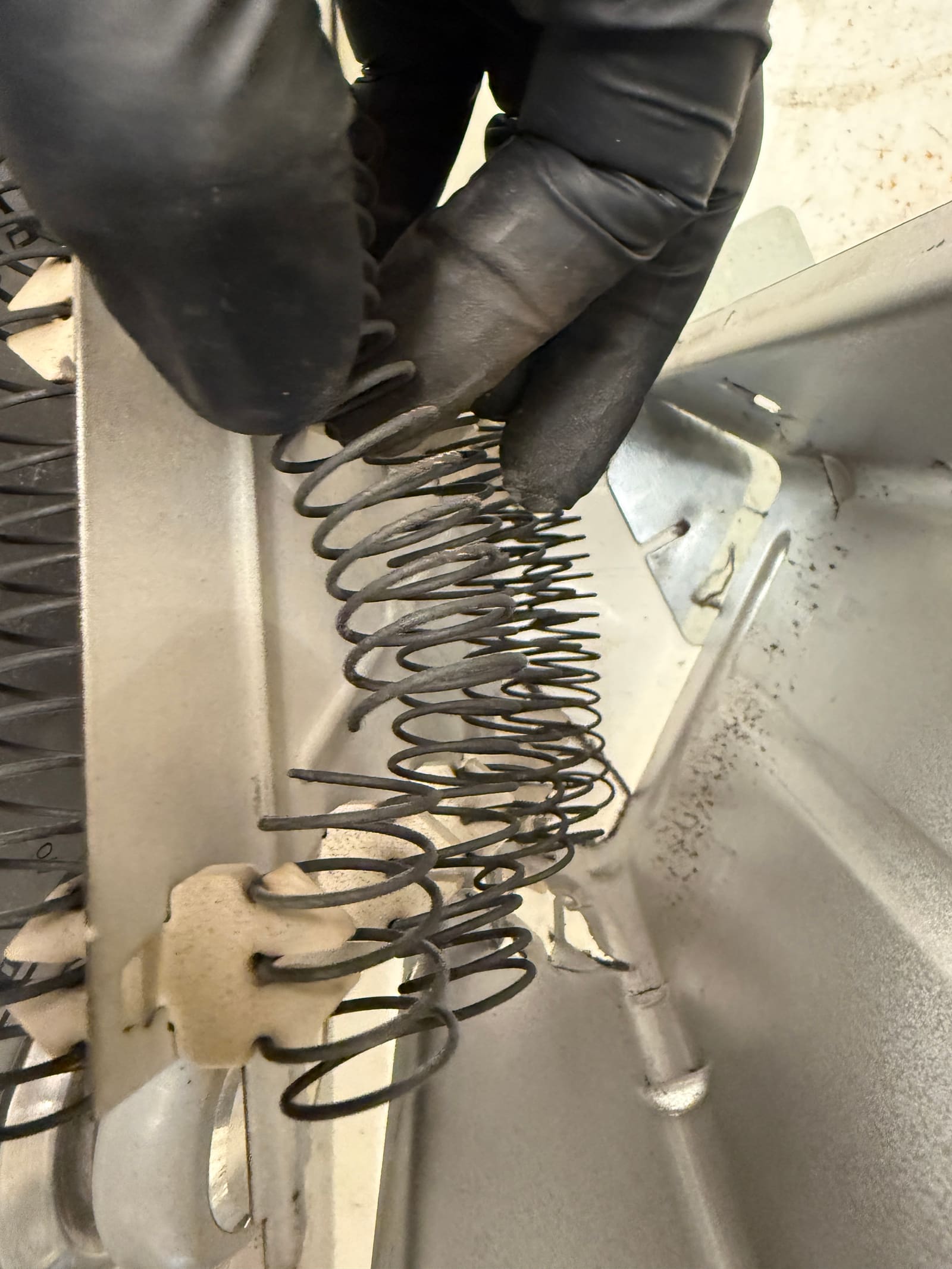 Inspecting the failed heating element coil from the Maytag dryer
