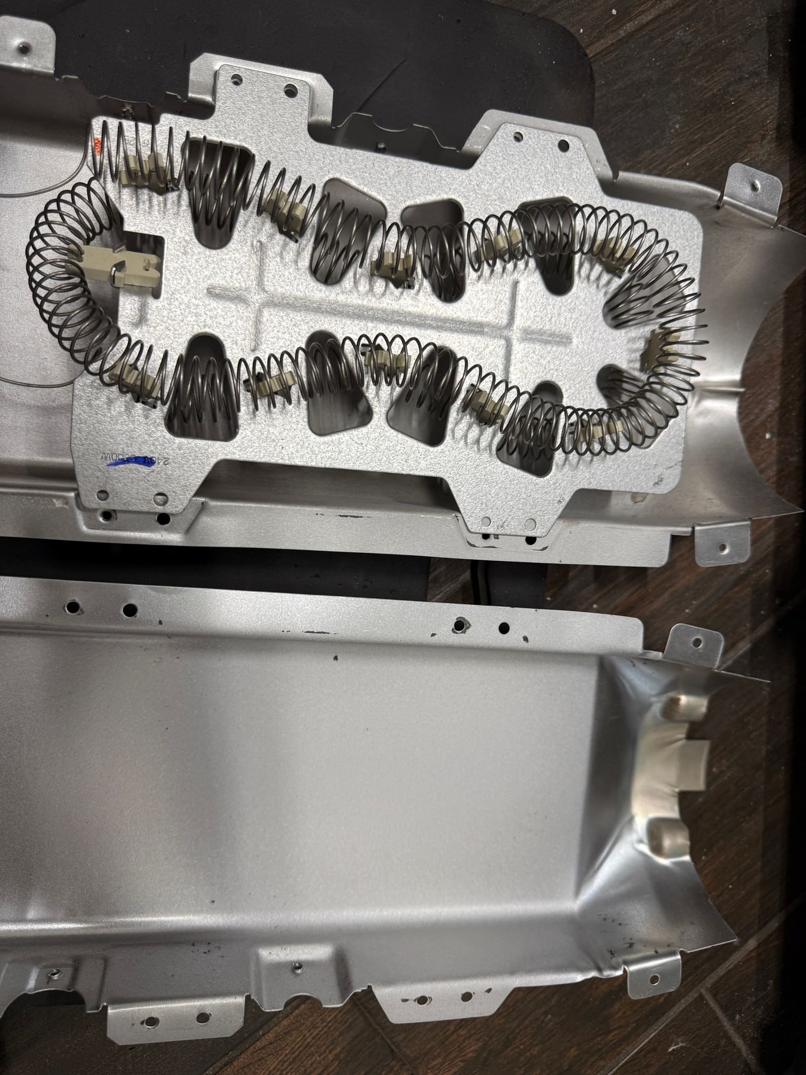 New heating element installed in the open heater can before reassembly