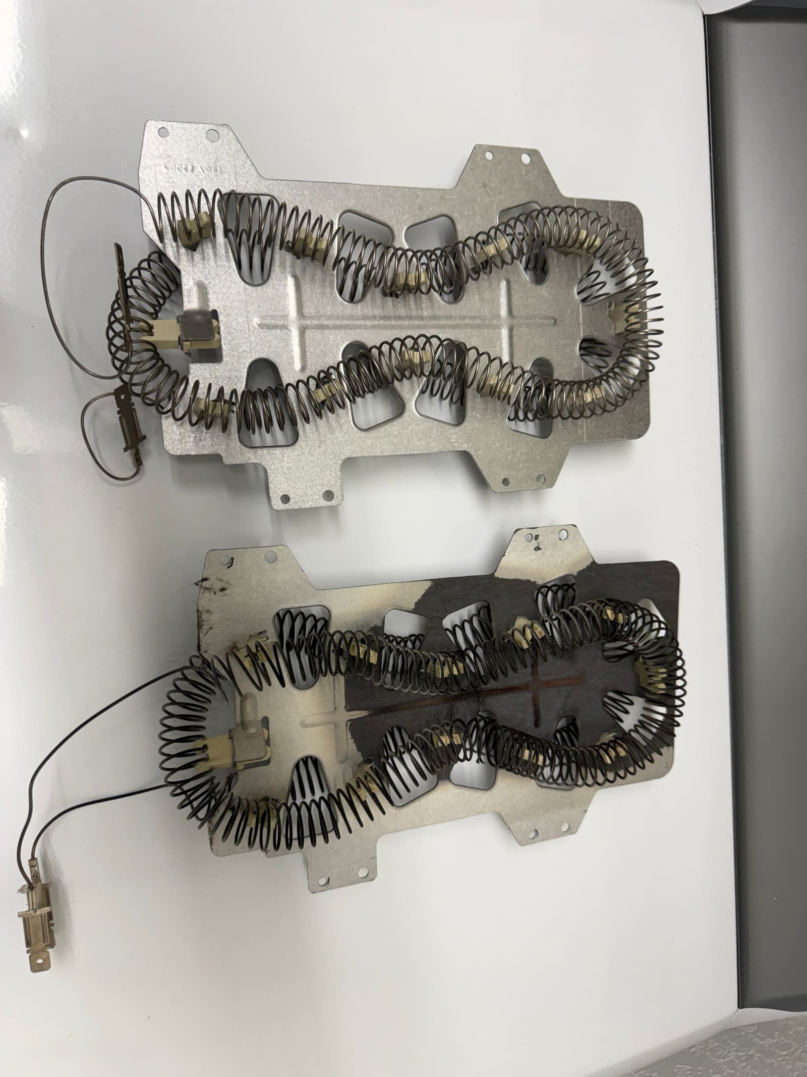 New Samsung dryer heating element above the old burnt one for comparison