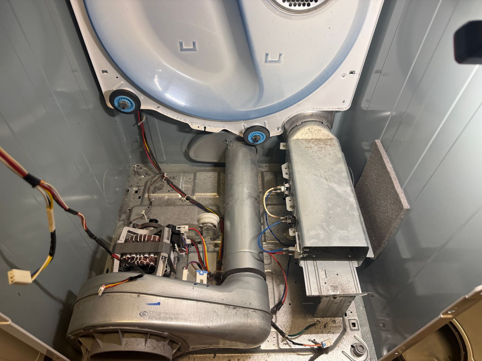 Inside the Samsung dryer cabinet with the drum removed, showing the blower housing and heating element ducting