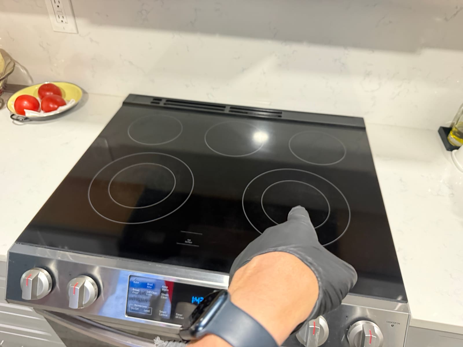 Technician pointing to the front right dual burner on the Samsung glass cooktop that wasn't heating