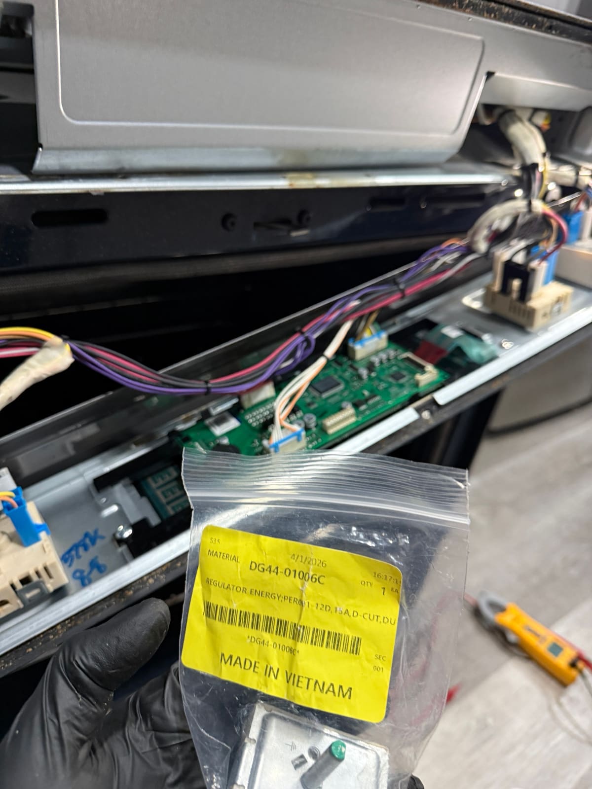 New Samsung burner switch, part DG44-01006C, in its bag in front of the open control panel