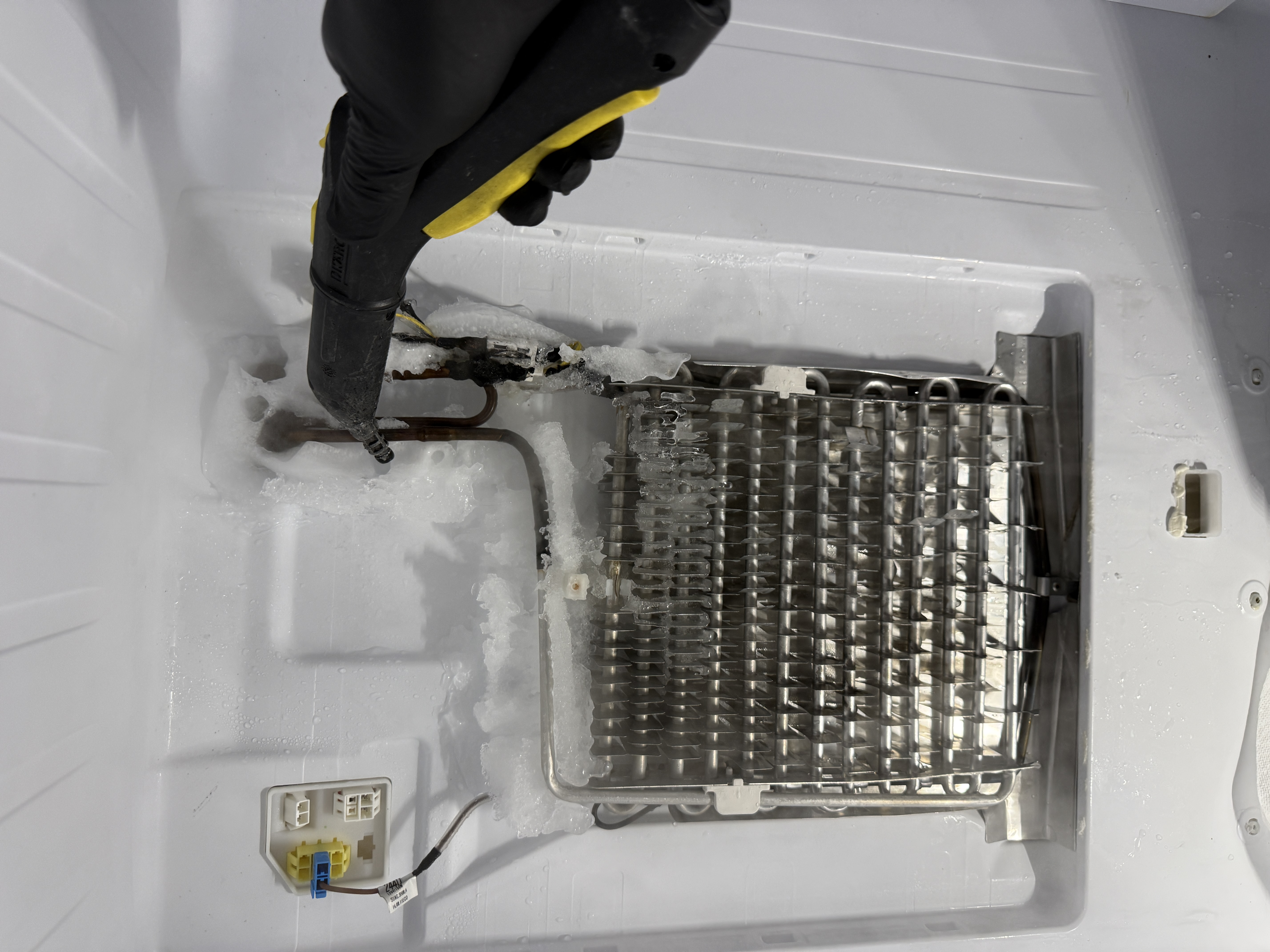 Ice buildup around the evaporator coil and fan area in the Samsung refrigerator