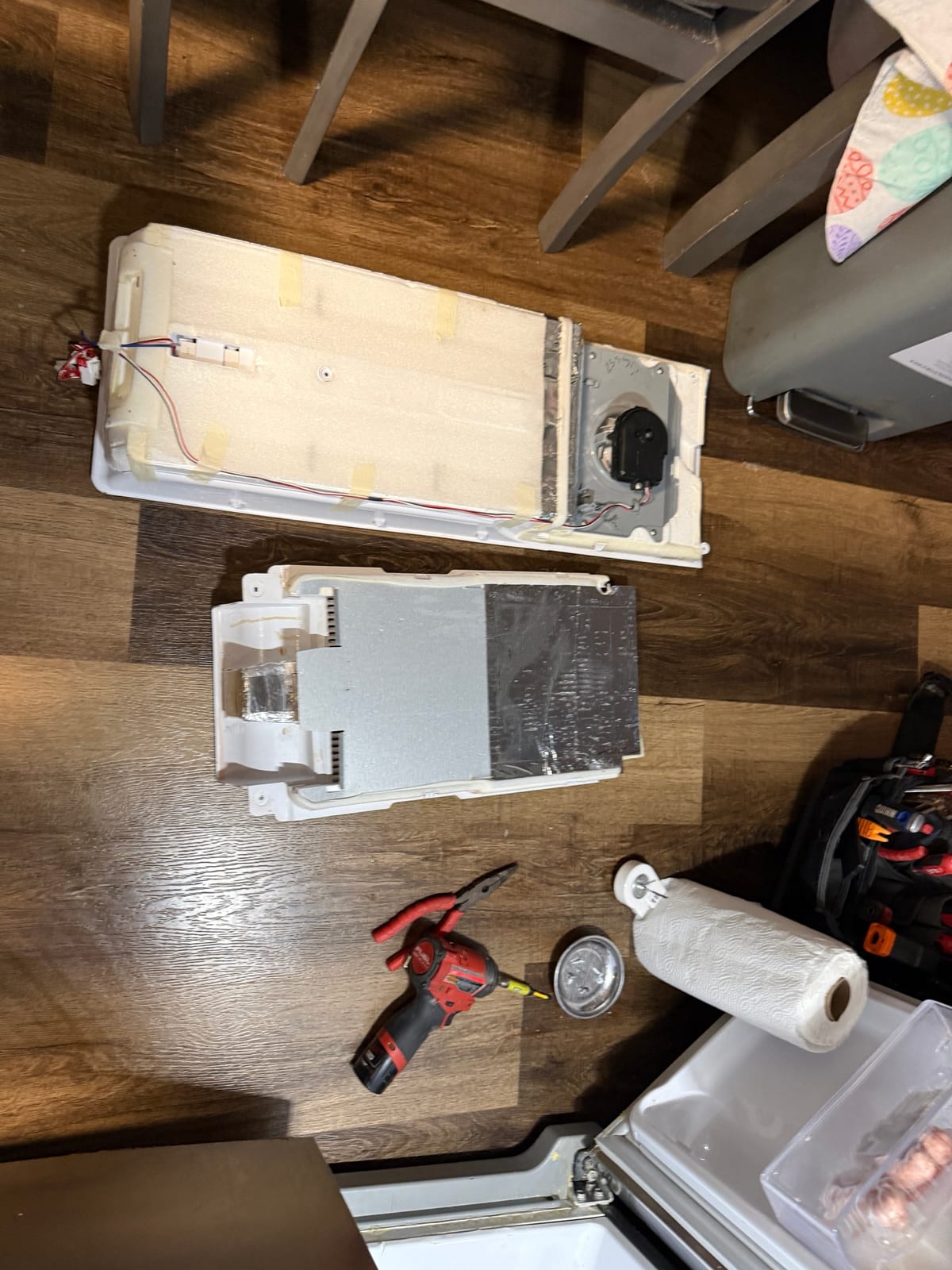 Samsung freezer rear panels laid out on the floor, one with the fan motor mounted on it