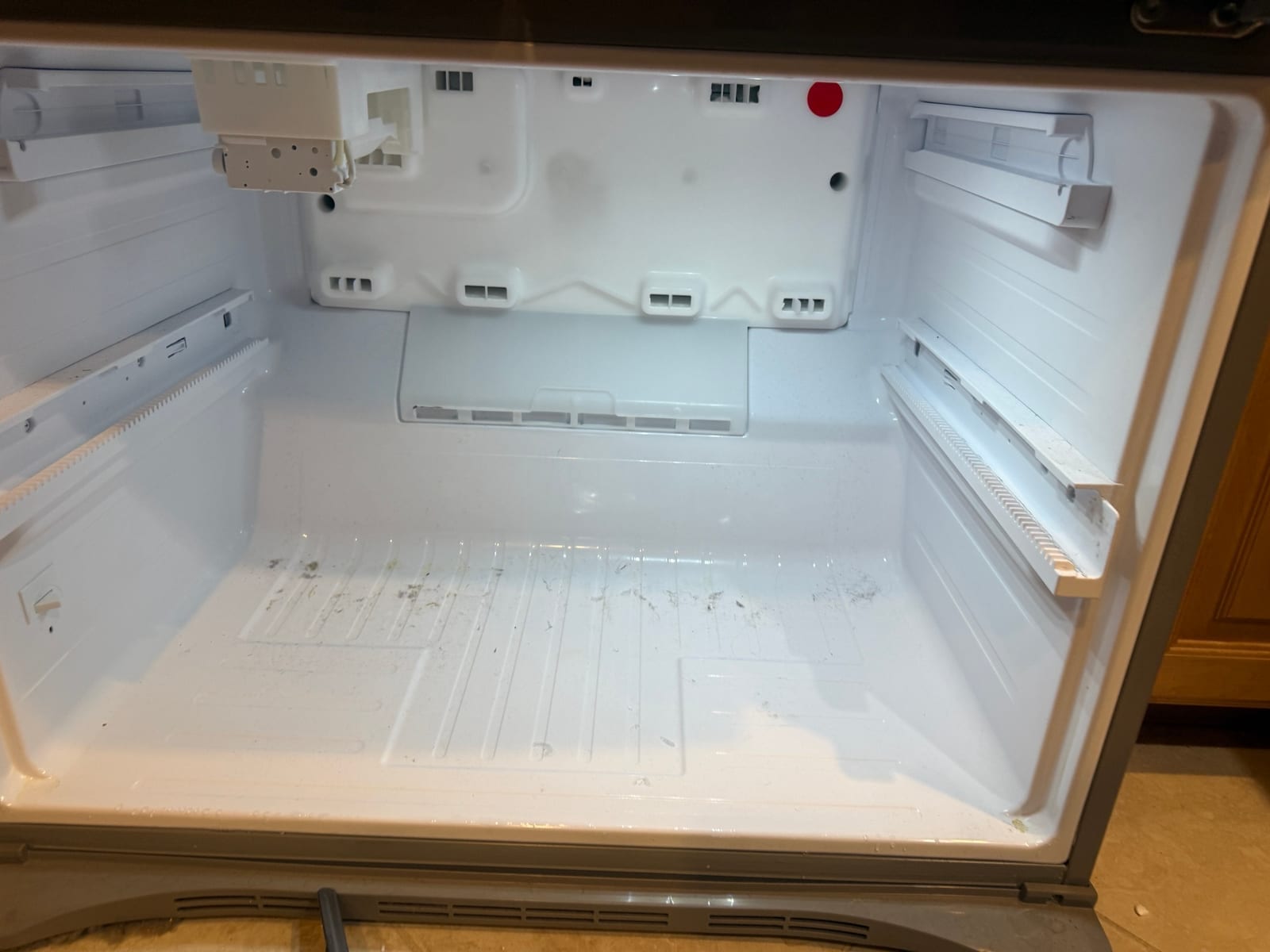 Emptied lower compartment of the Samsung refrigerator with the ice maker at the top