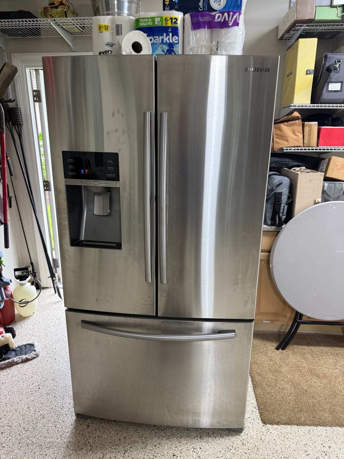 Samsung stainless French door refrigerator with a dispenser in a garage in the East Lake Woodlands neighborhood of Palm Harbor