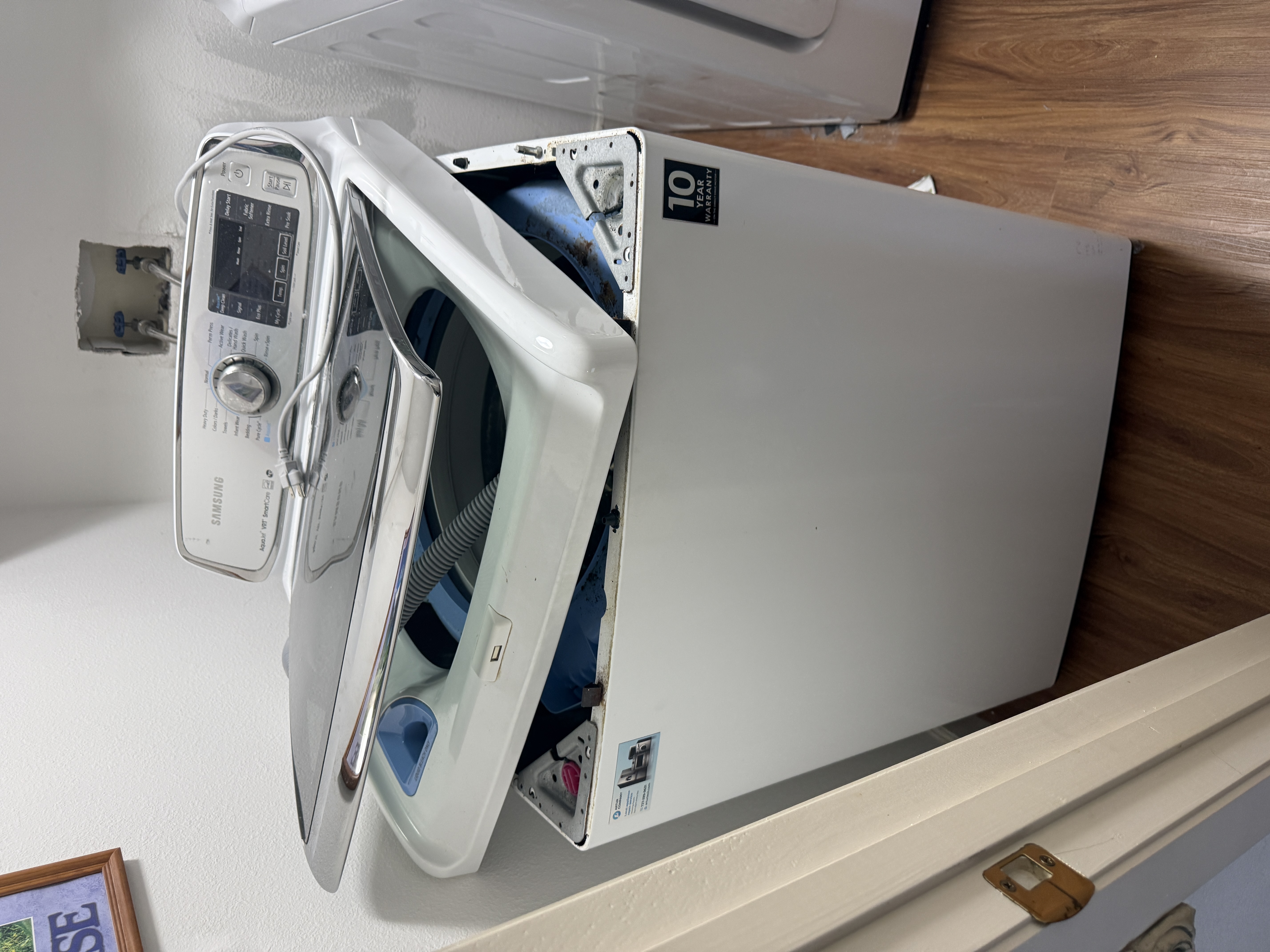 Top panel removed from the Samsung washer, exposing the tub and suspension mounts