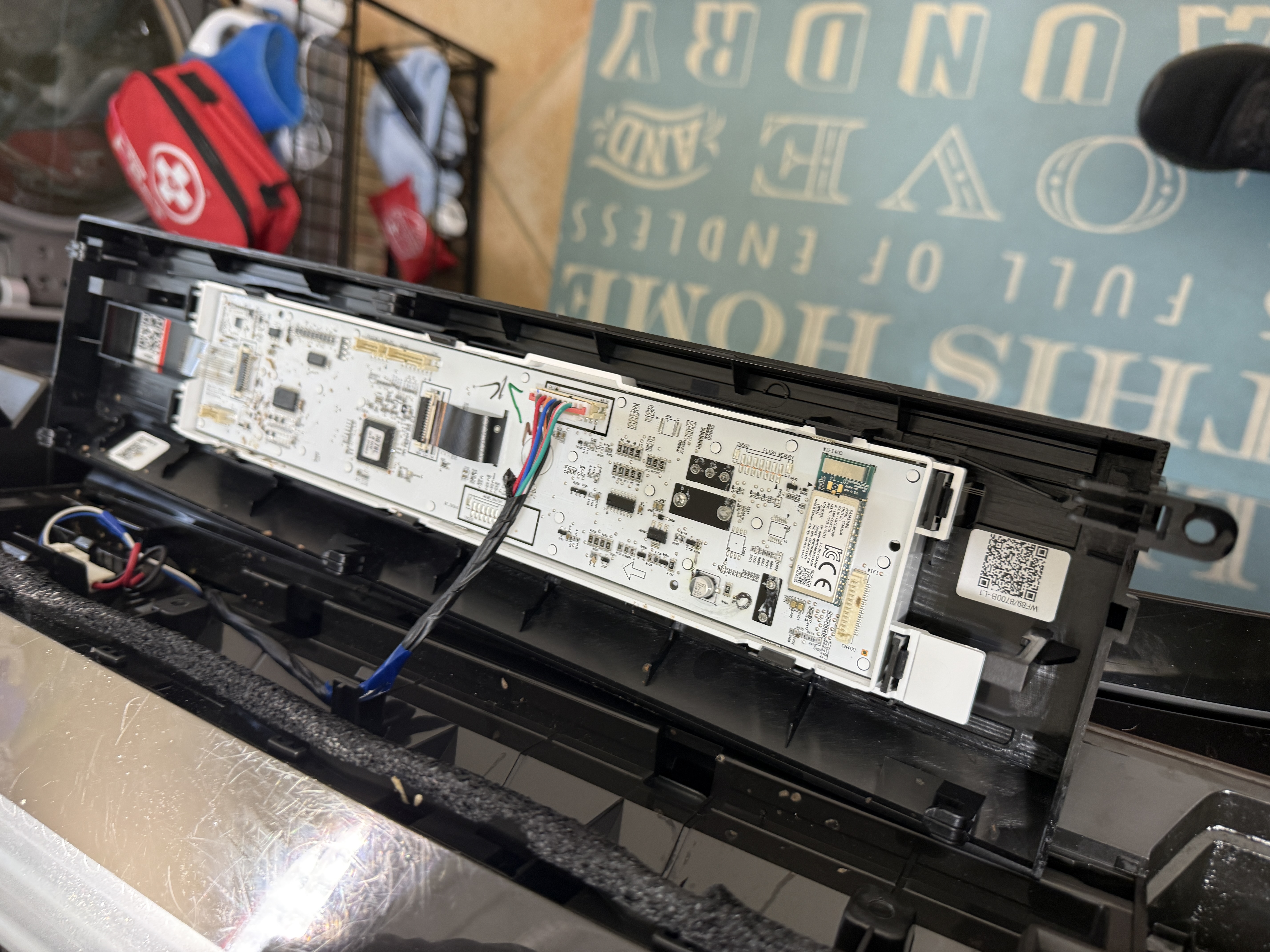 Control panel removed from the Samsung front-load washer, exposing the display and control boards