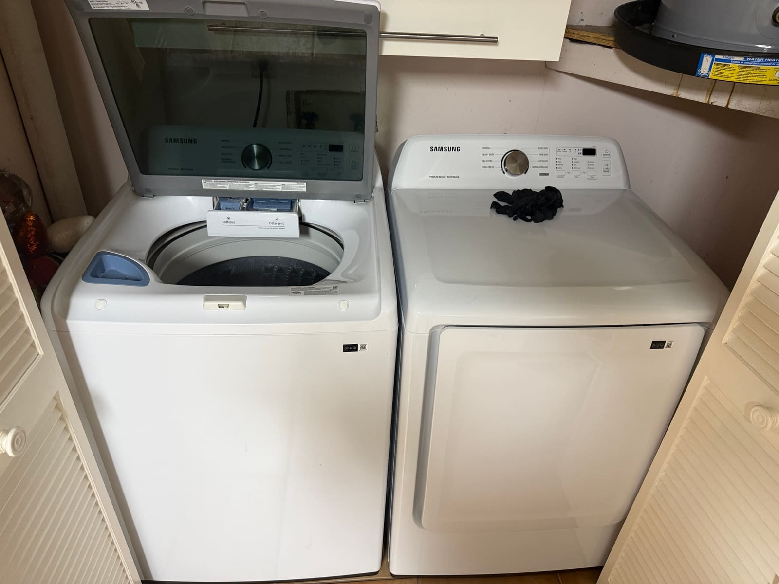 Samsung top-load washer with the lid open next to a matching Samsung dryer in a laundry closet in Safety Harbor