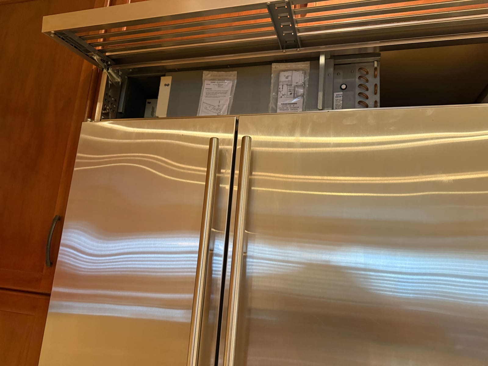 Service compartment above the Sub-Zero refrigerator opened up to access the control board