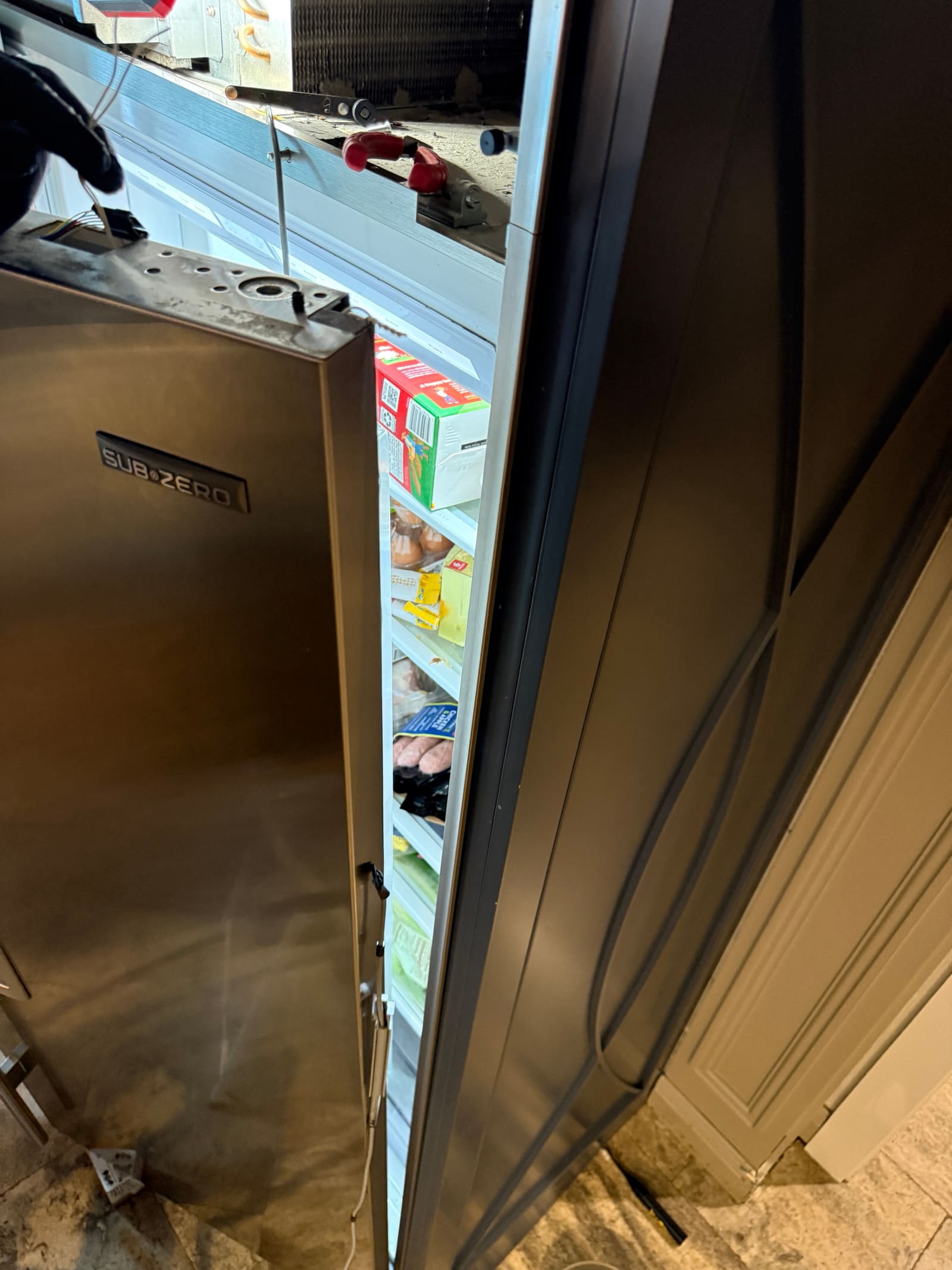 Sub-Zero refrigerator door swung open away from the cabinet during the repair