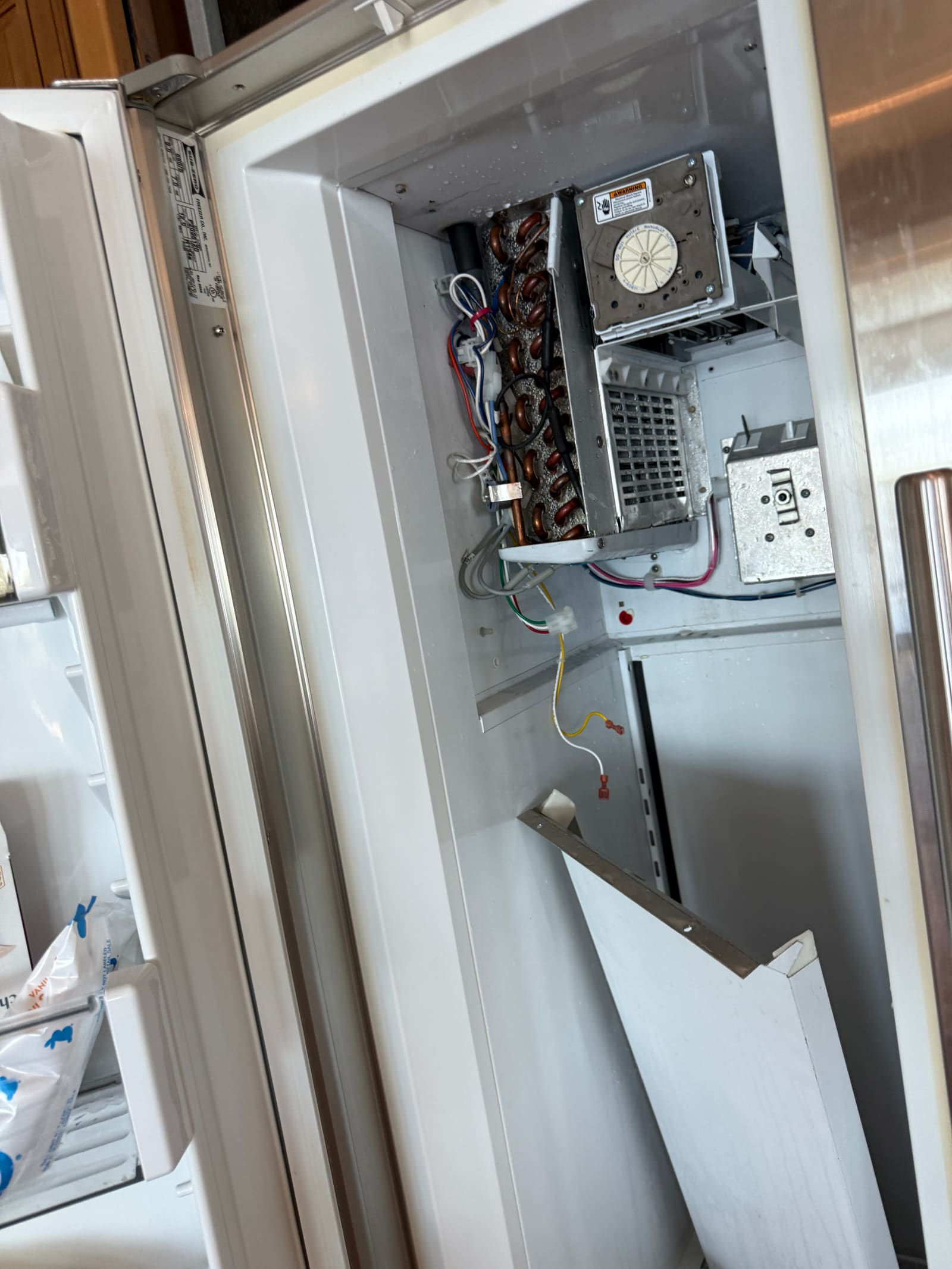 Open evaporator compartment inside the Sub-Zero freezer showing the coil and icemaker assembly